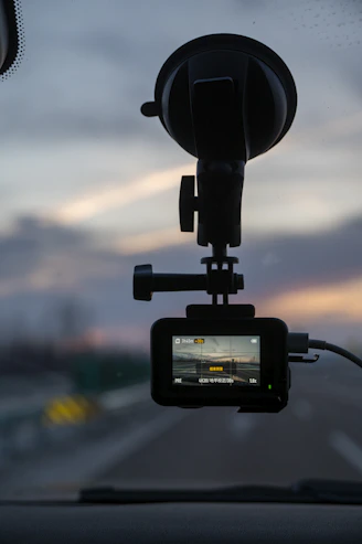 Action camera mounted on car windshield at sunset