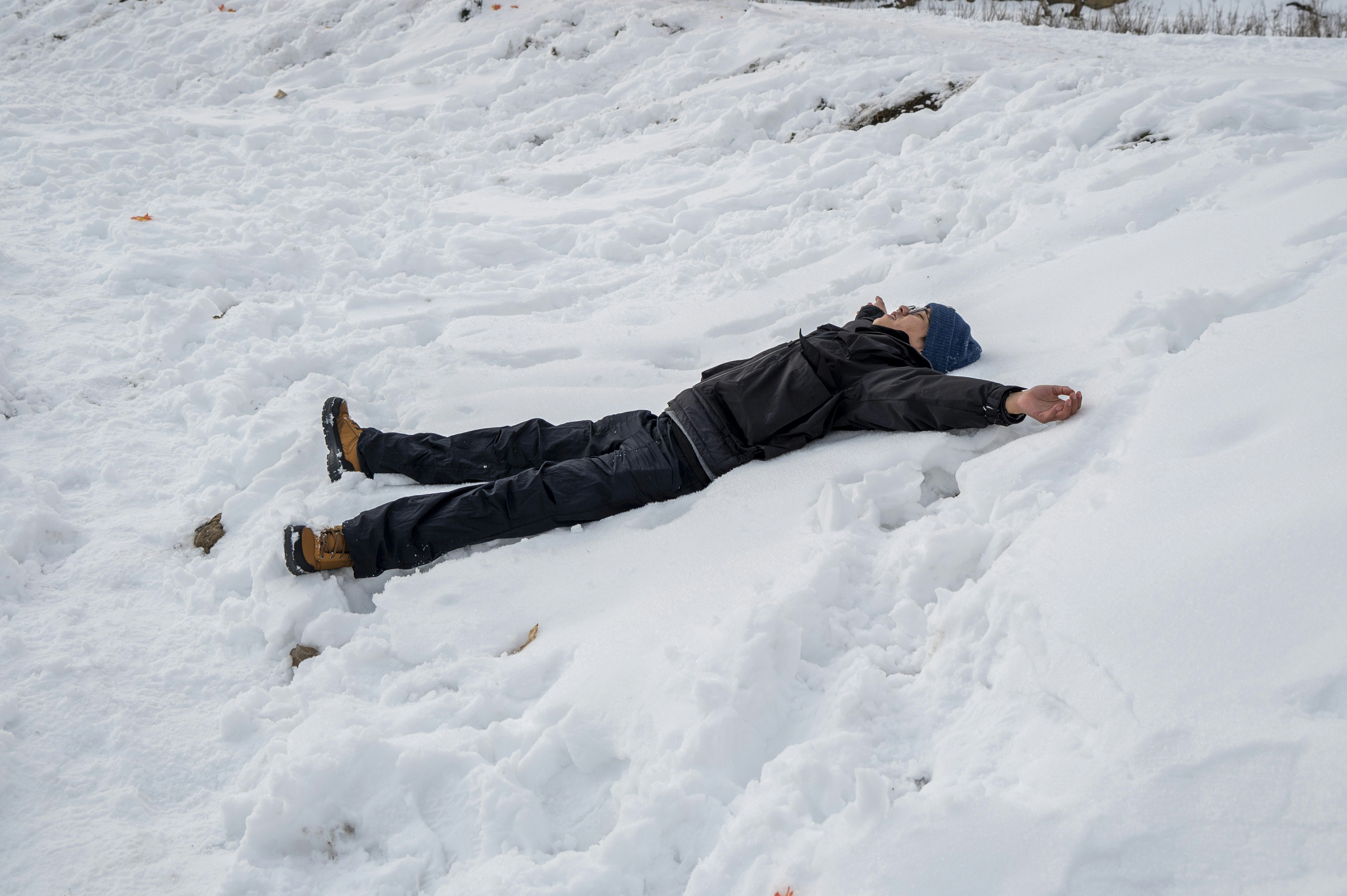 A person lying on their back in the snow