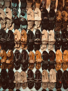A wall of assorted leather sandals and shoes.