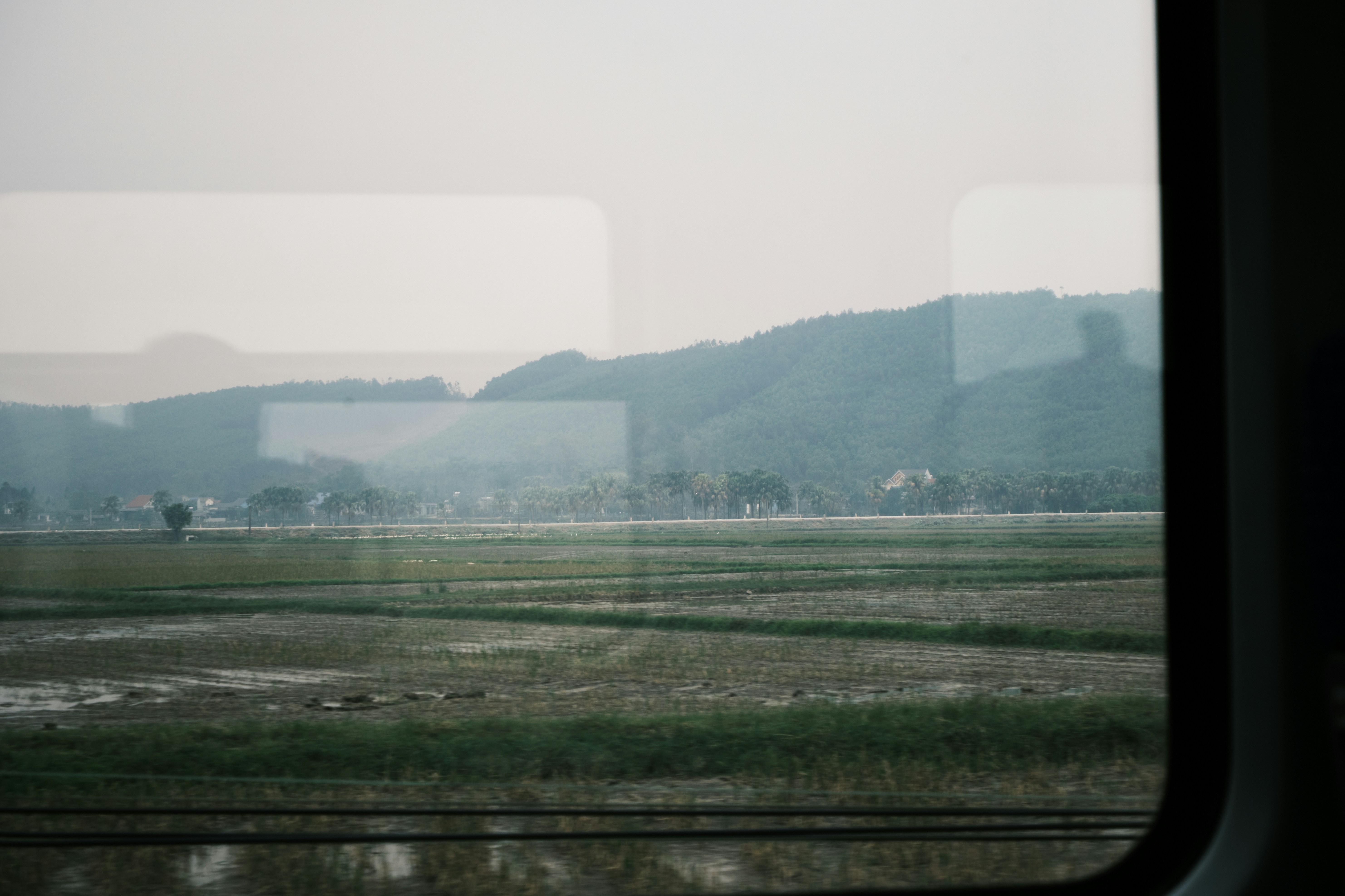 View of green fields and hills from a window