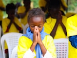 Young girl praying with hands clasped