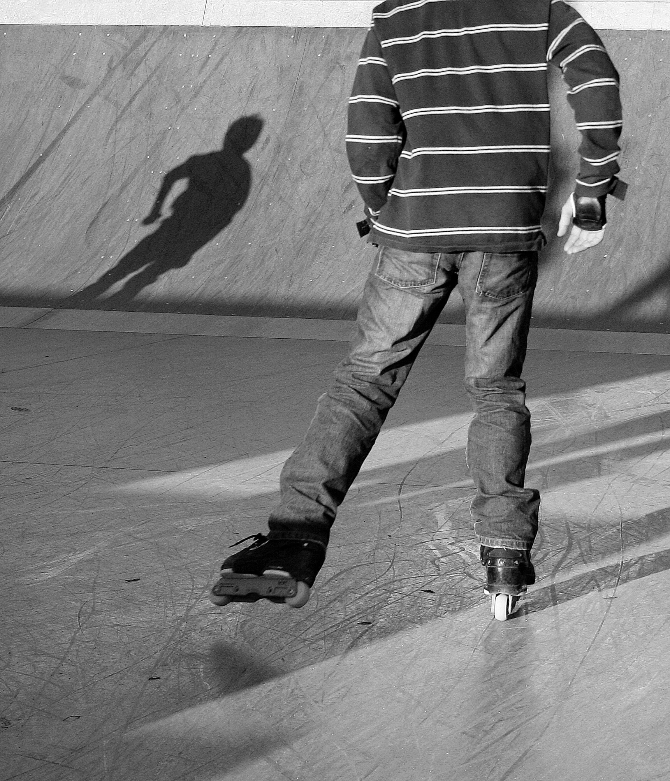 A person ice skating casting a long shadow