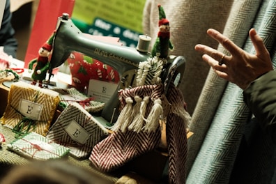 Vintage sewing machine decorated with elves and fabric.
