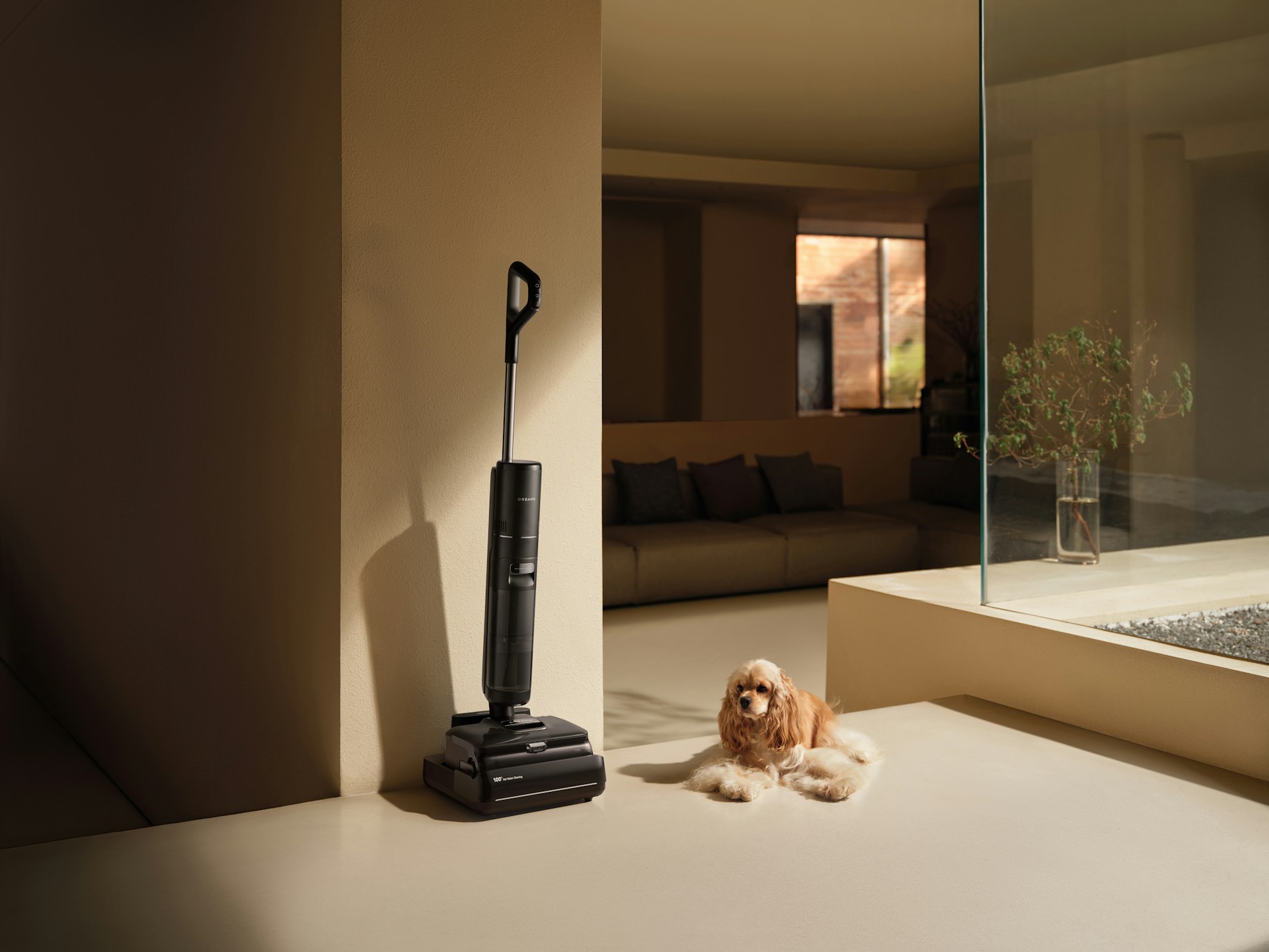 Cordless vacuum cleaner and small dog on floor.