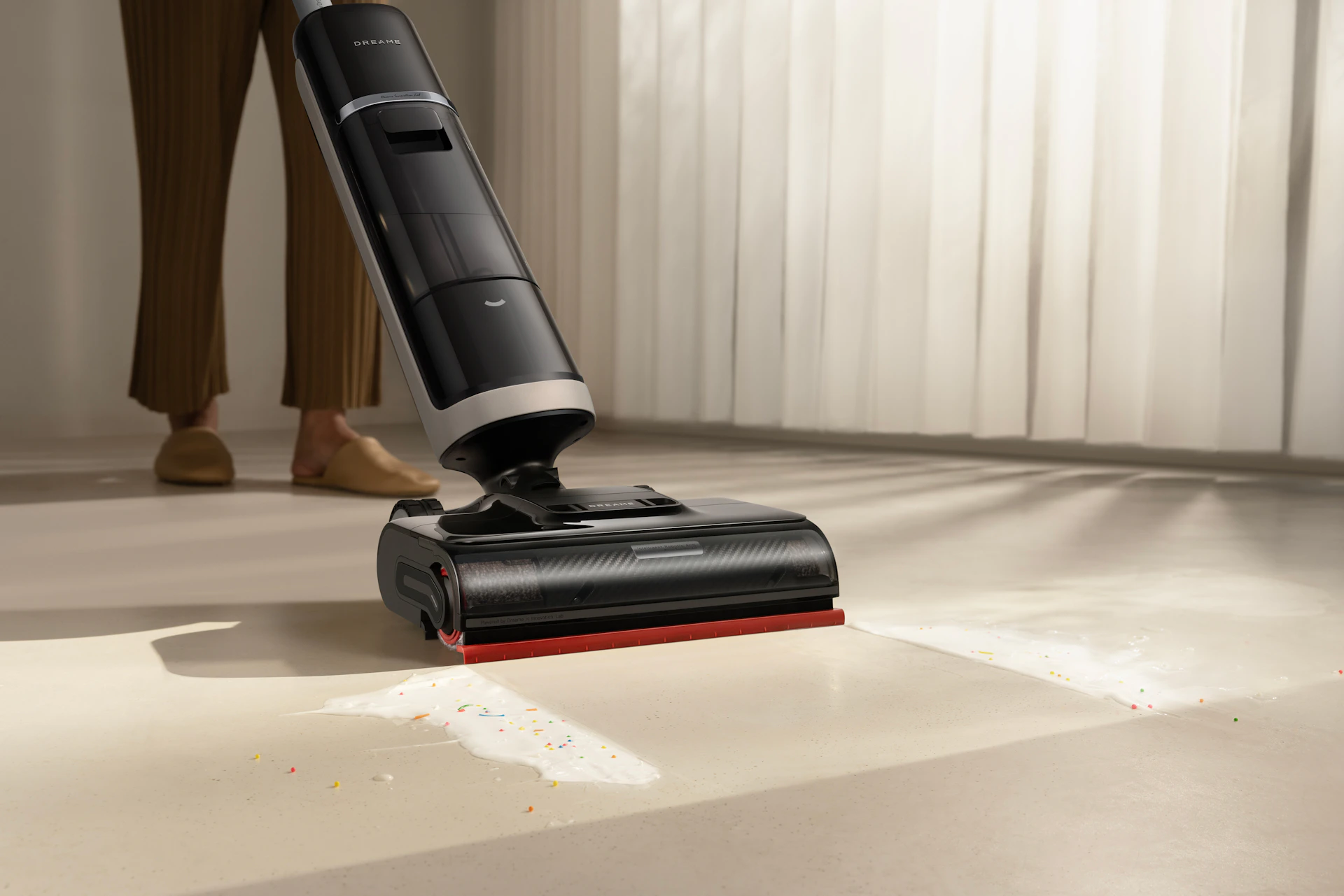 A person using a cordless vacuum cleaner on a floor.
