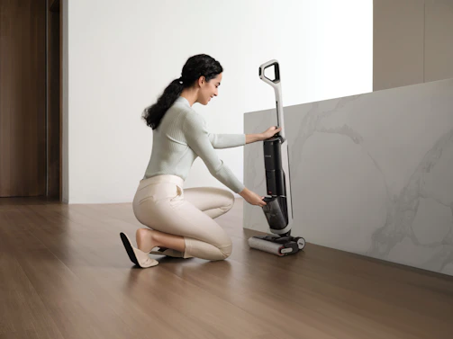 Woman cleaning floor with a wet dry vacuum cleaner.