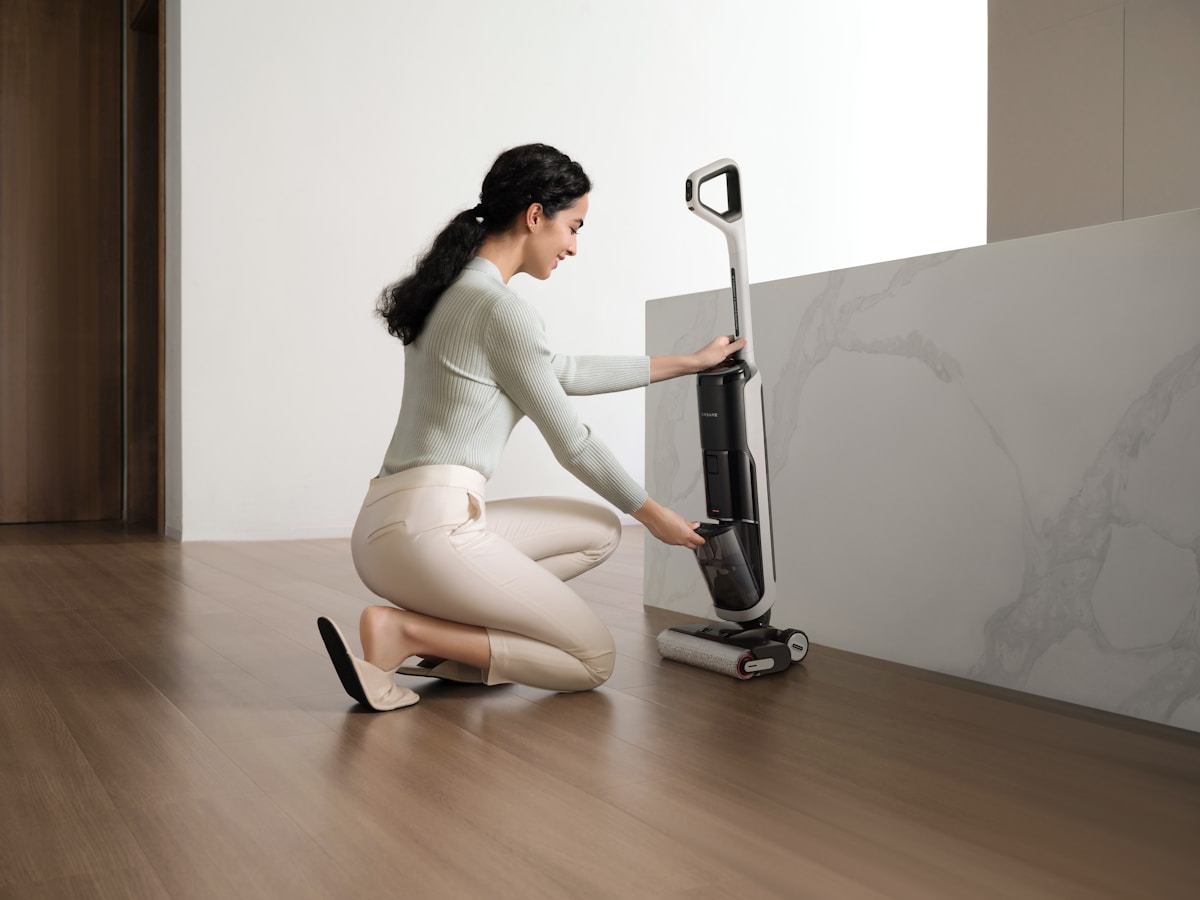 Woman cleaning floor with a wet dry vacuum cleaner.