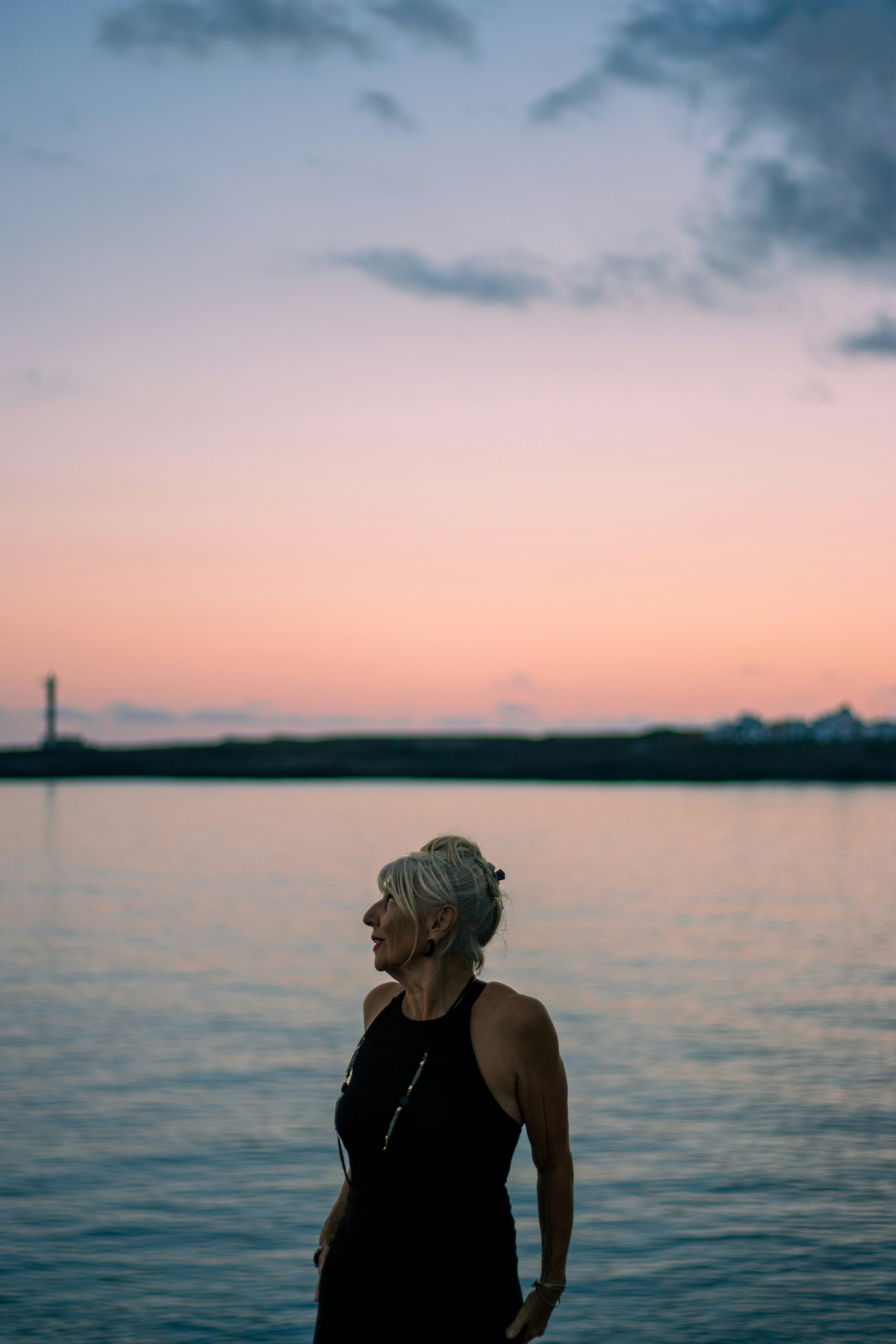Woman looking out at the water during sunset