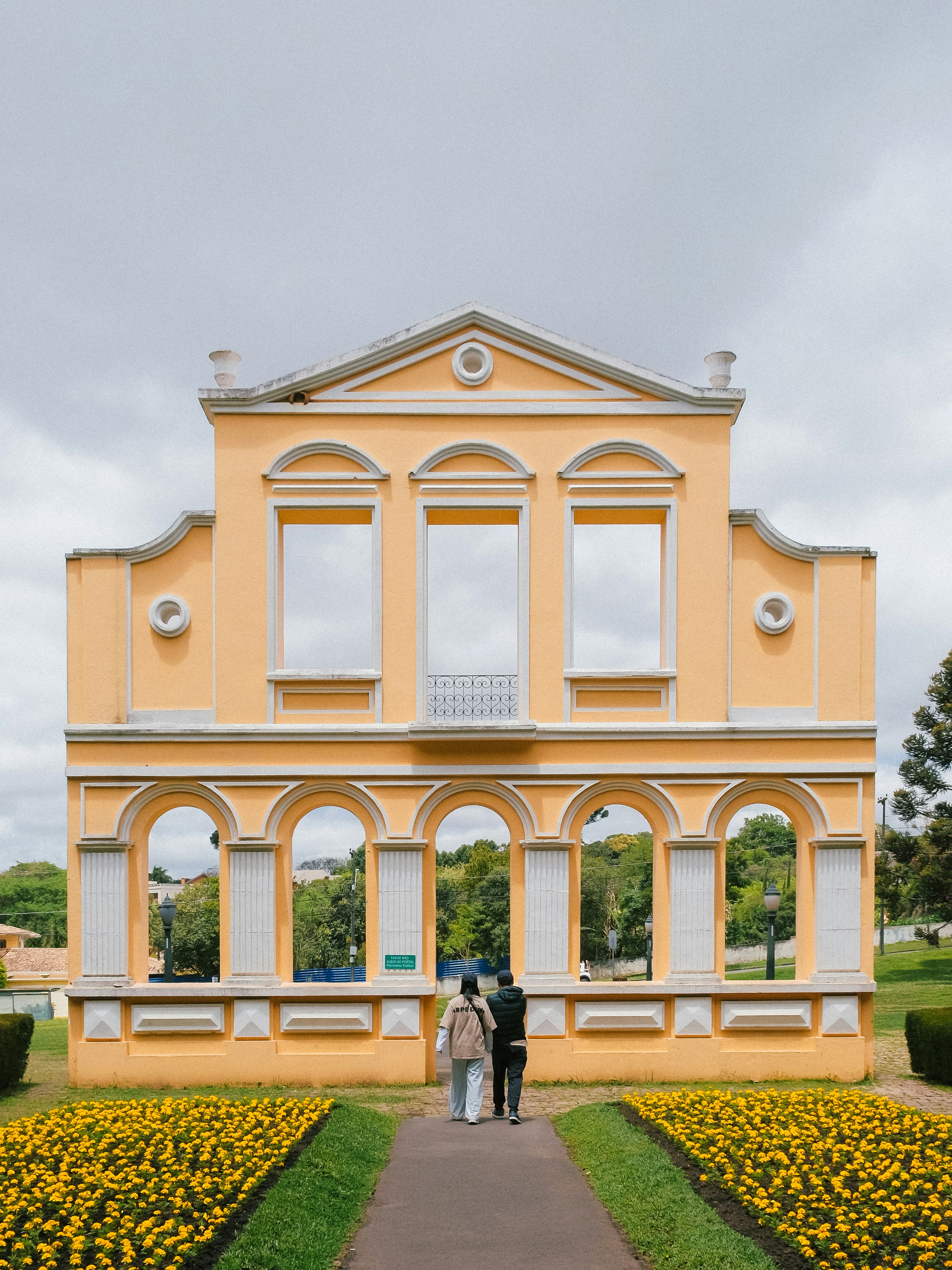 Das Paar geht zur gelben Gebäudefassade mit Bögen