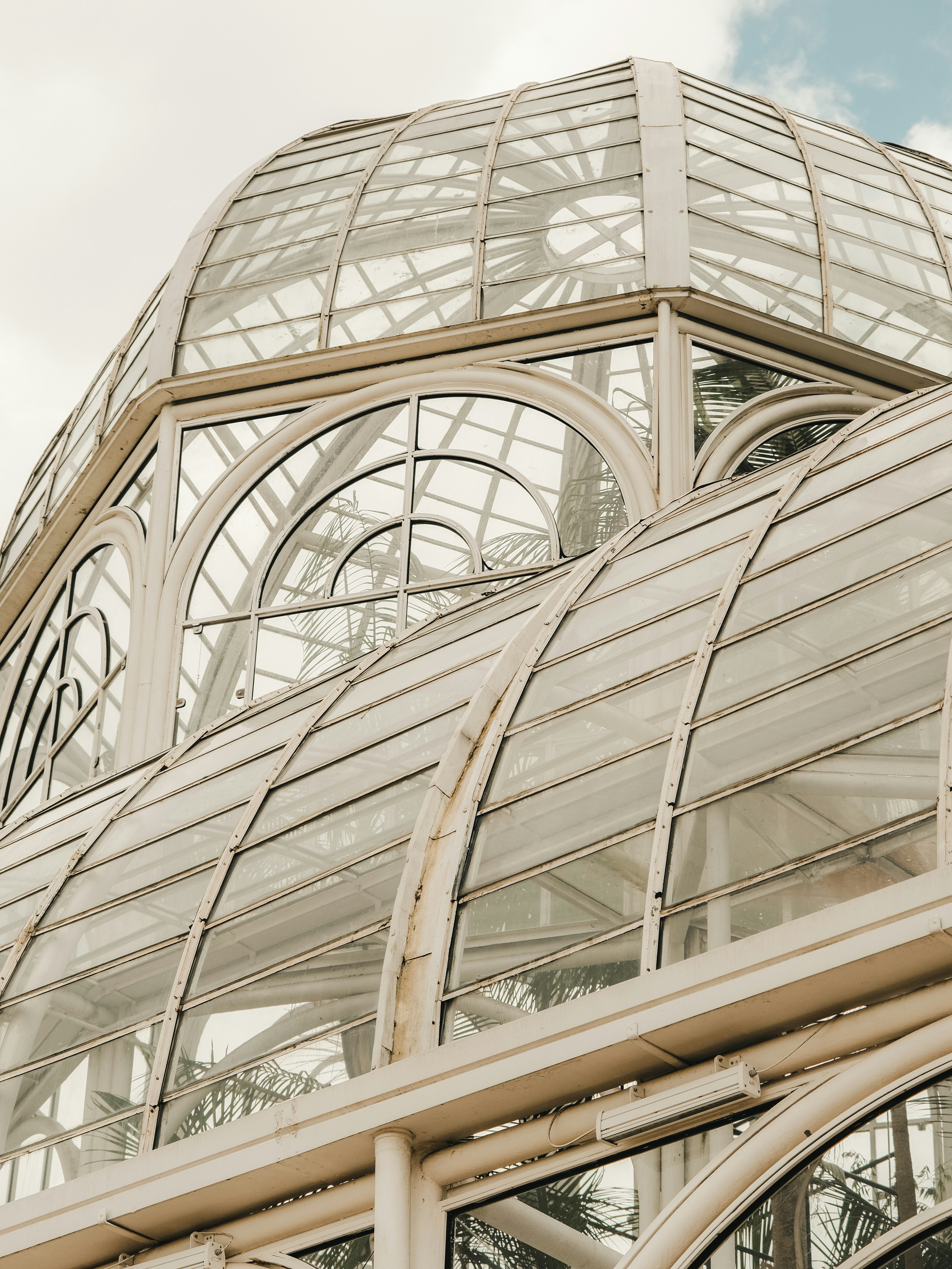 Verziertes Glasgewächshaus mit Bogenfenstern und weißem Rahmen