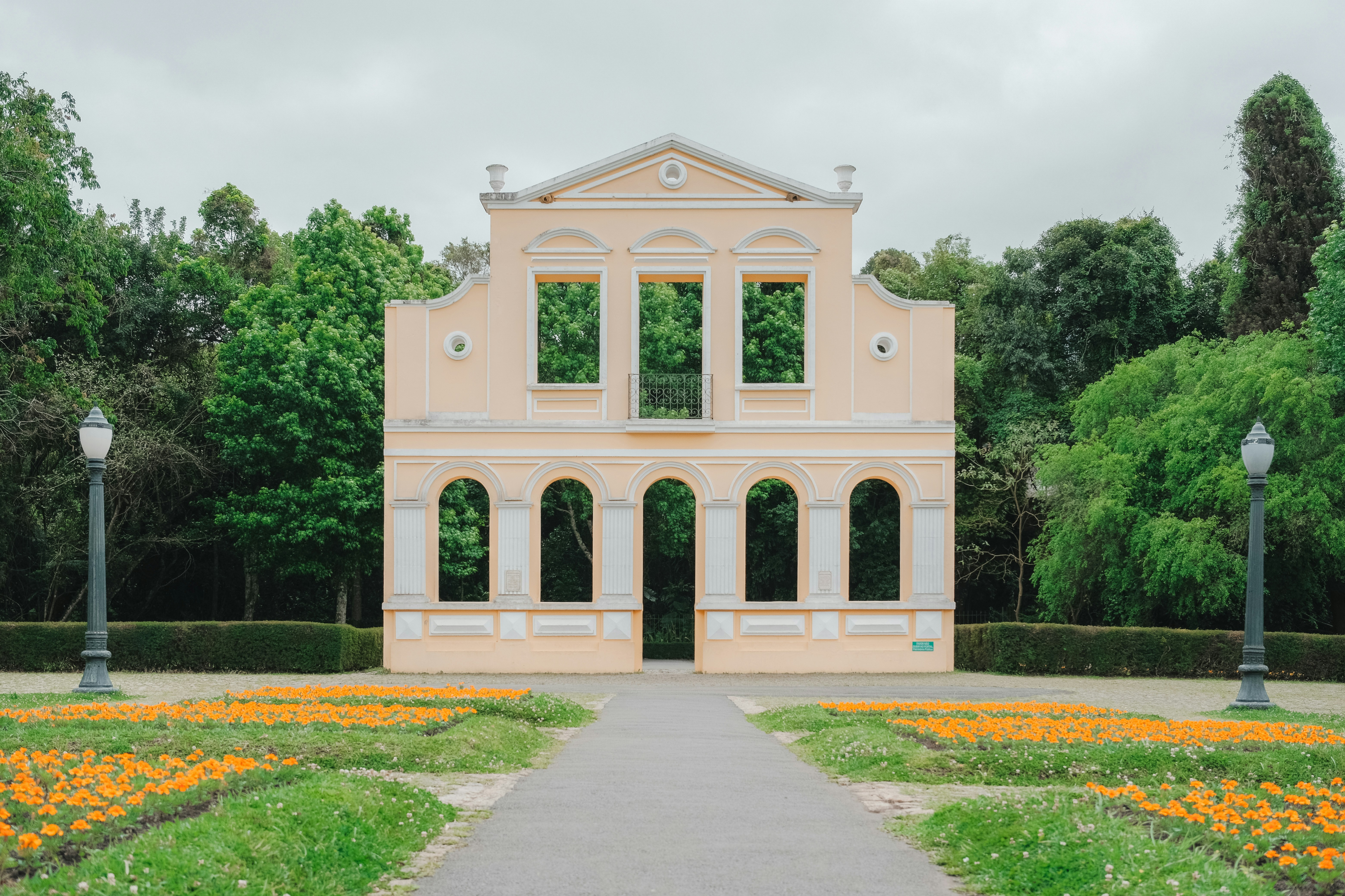 Historische Gebäudefassade, umgeben von üppig grünen Bäumen.