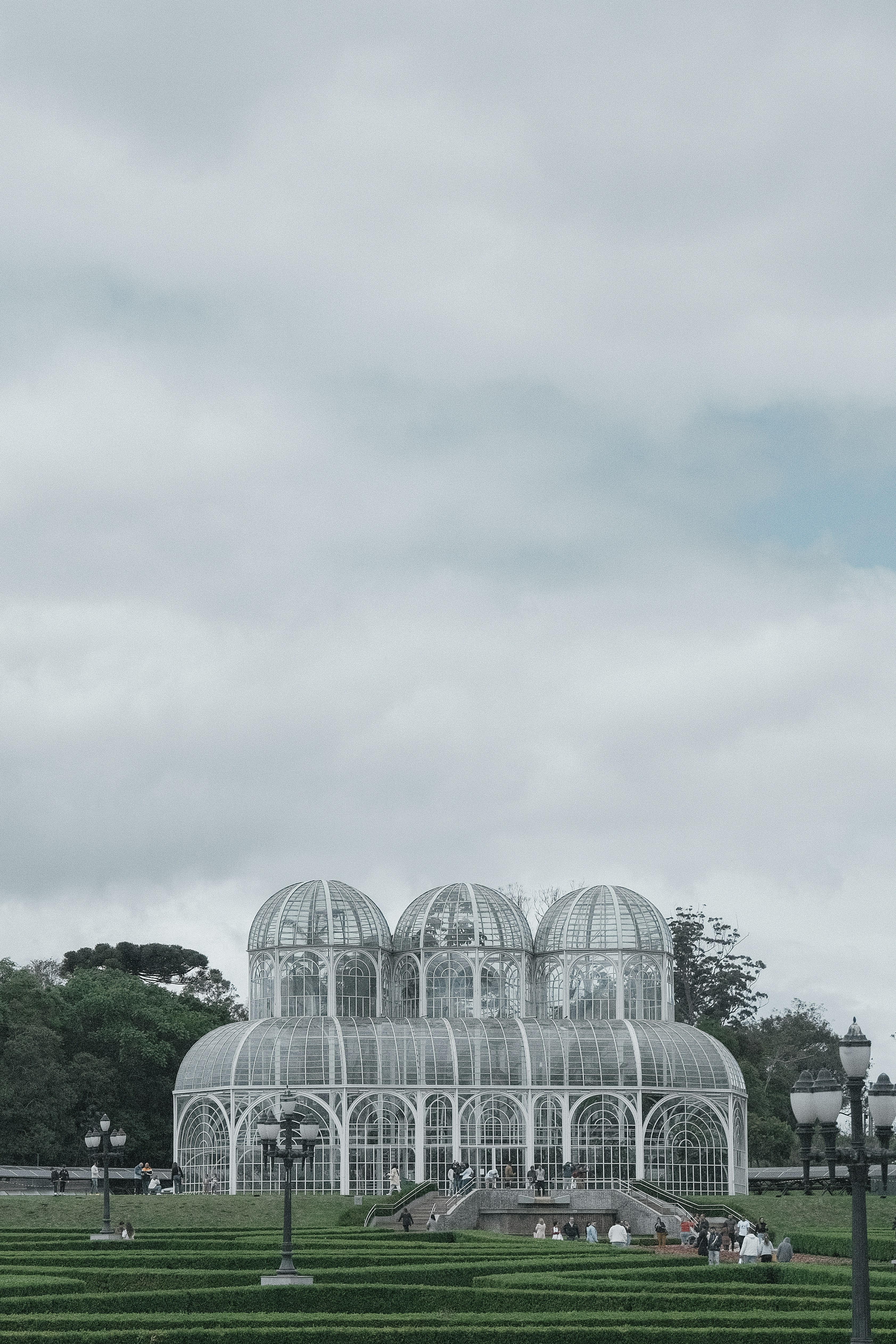 Glasbotanischer Garten mit drei Kuppeln unter bewölktem Himmel
