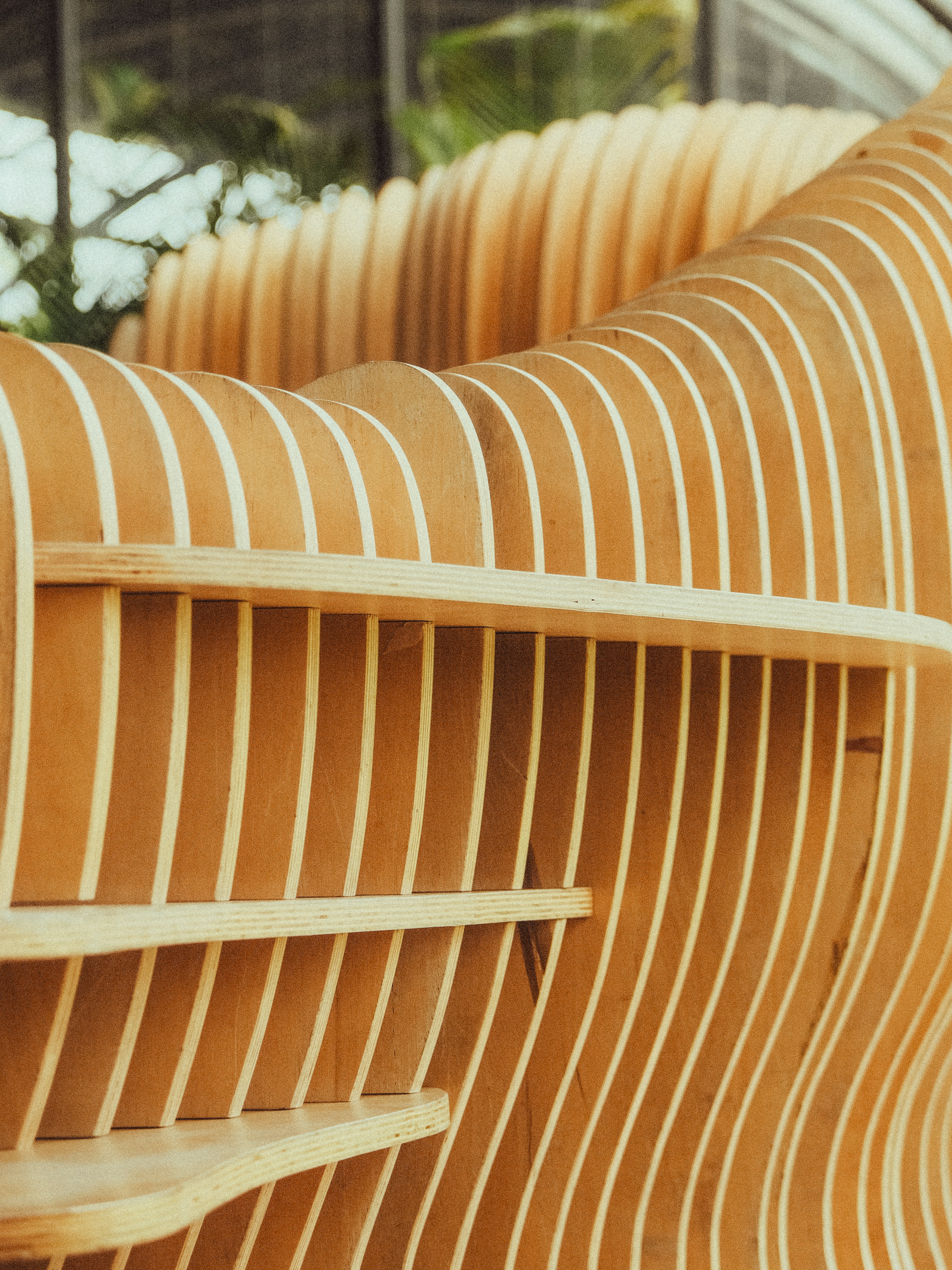 Gebogene Holzkonstruktion mit Regalen und senkrechten Latten