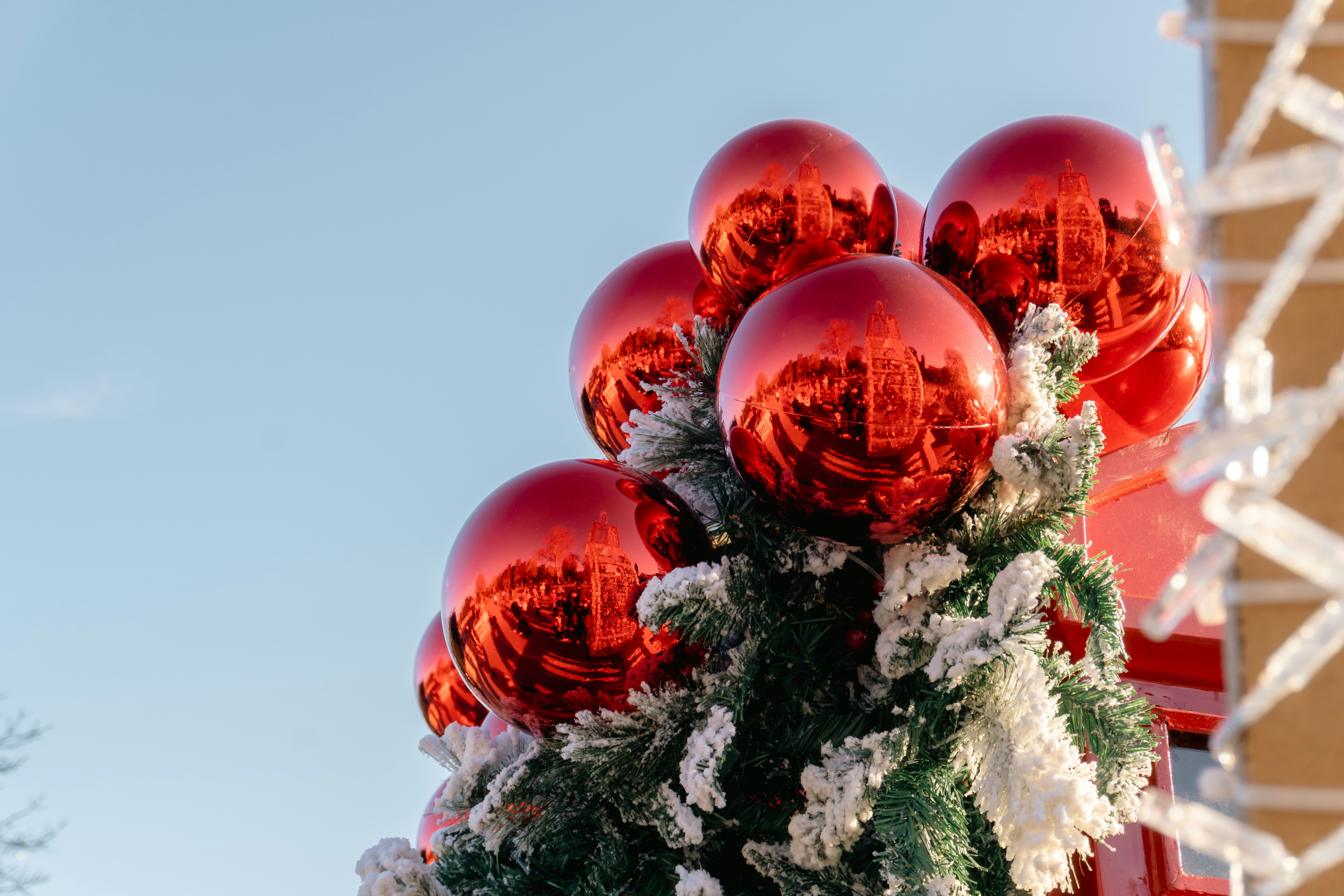 Rote Weihnachtskugeln an einem verschneiten Baum