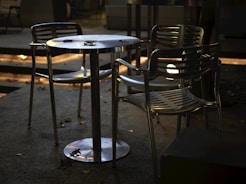 Empty outdoor cafe table and chairs at night