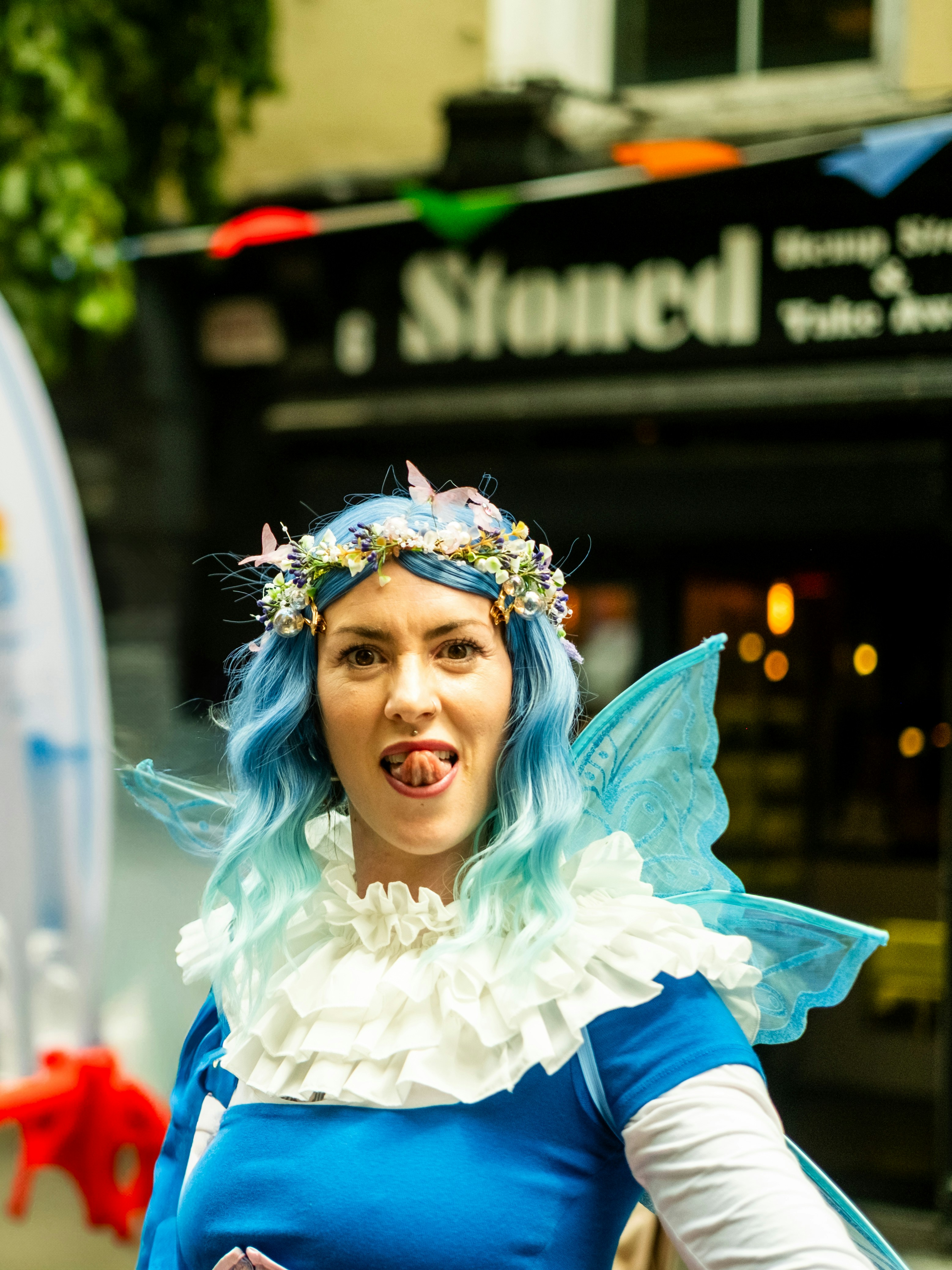 Woman in fairy costume with blue hair and wings