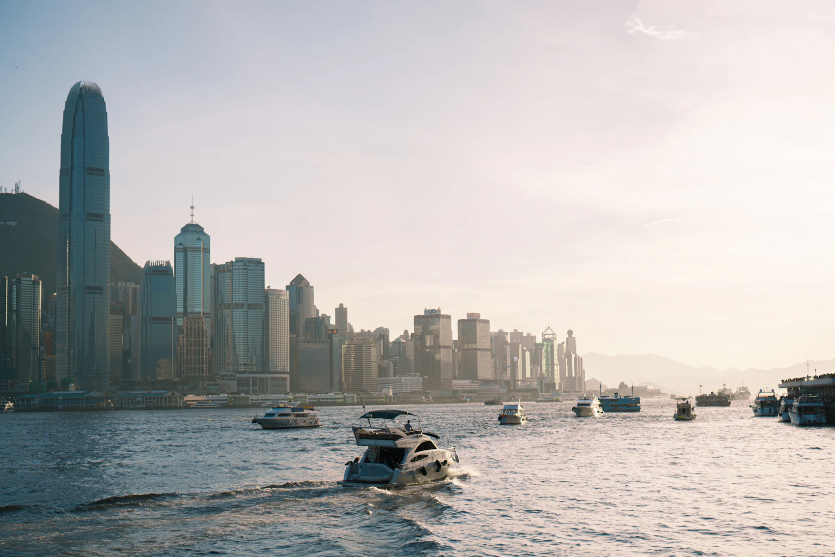 Boats crossing Victoria Harbour beneath the Hong Kong skyline