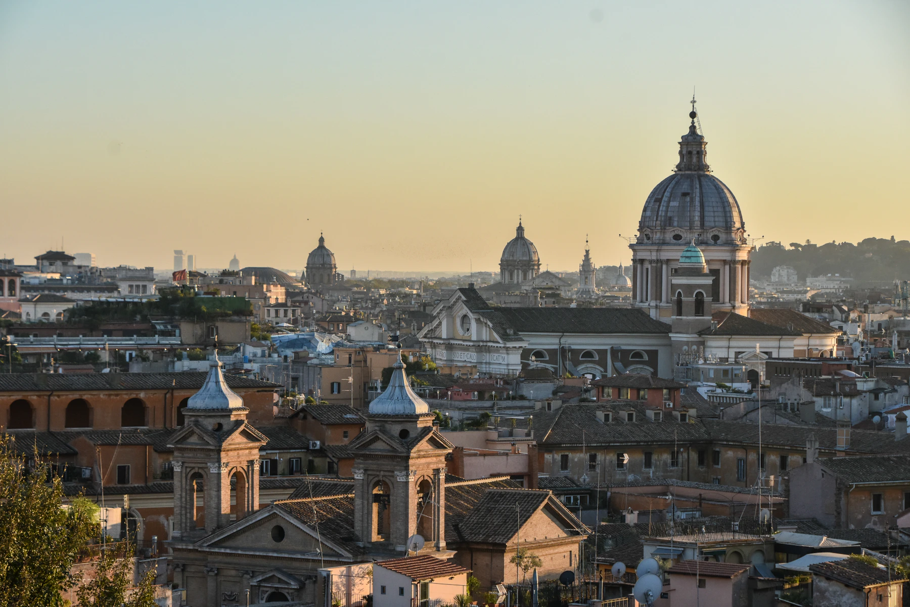 The rooftops, church domes and historic skyline of Rome in warm evening light
