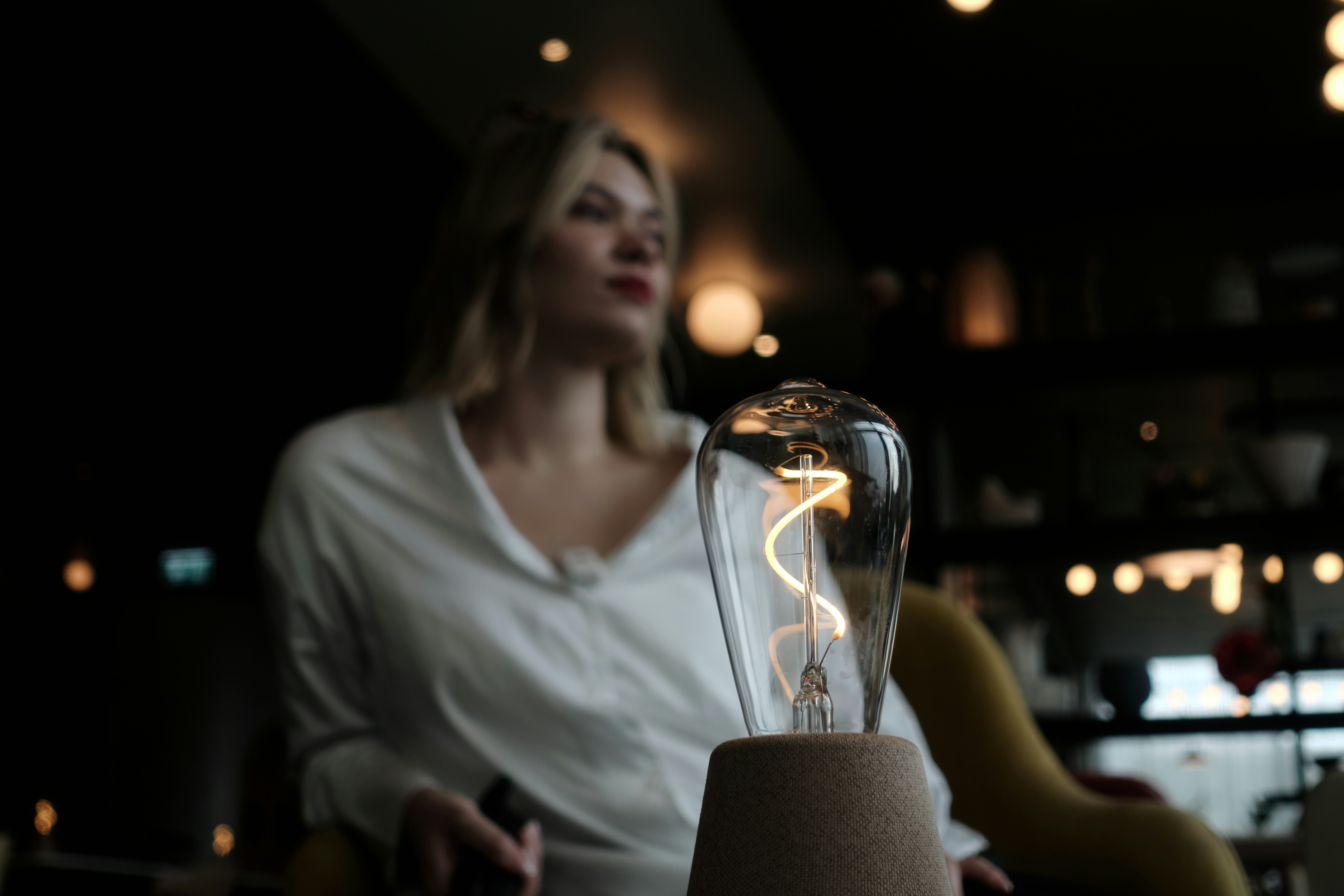 Woman in white shirt with illuminated edison bulb