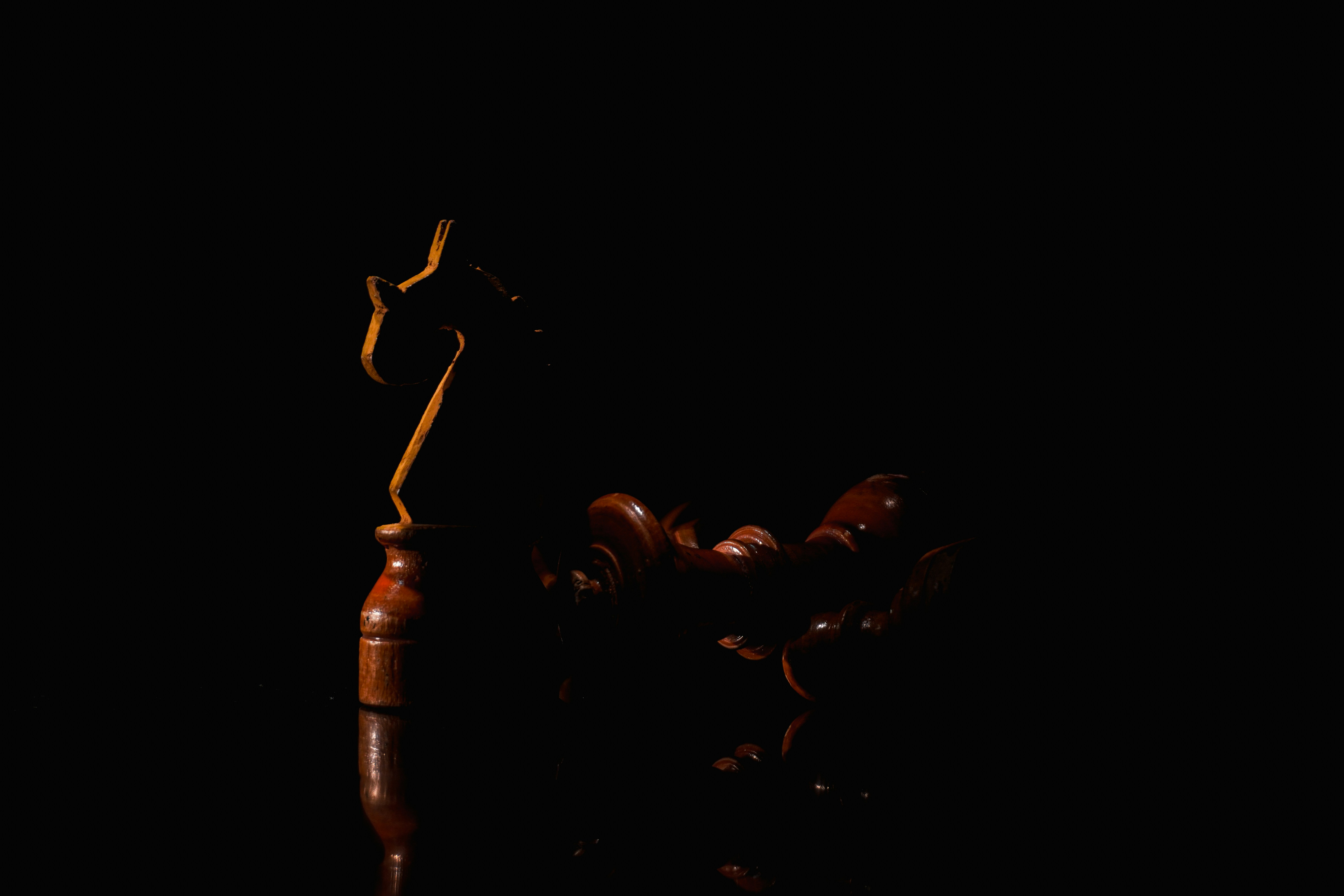 Um martelo de madeira repousa sobre um fundo escuro.