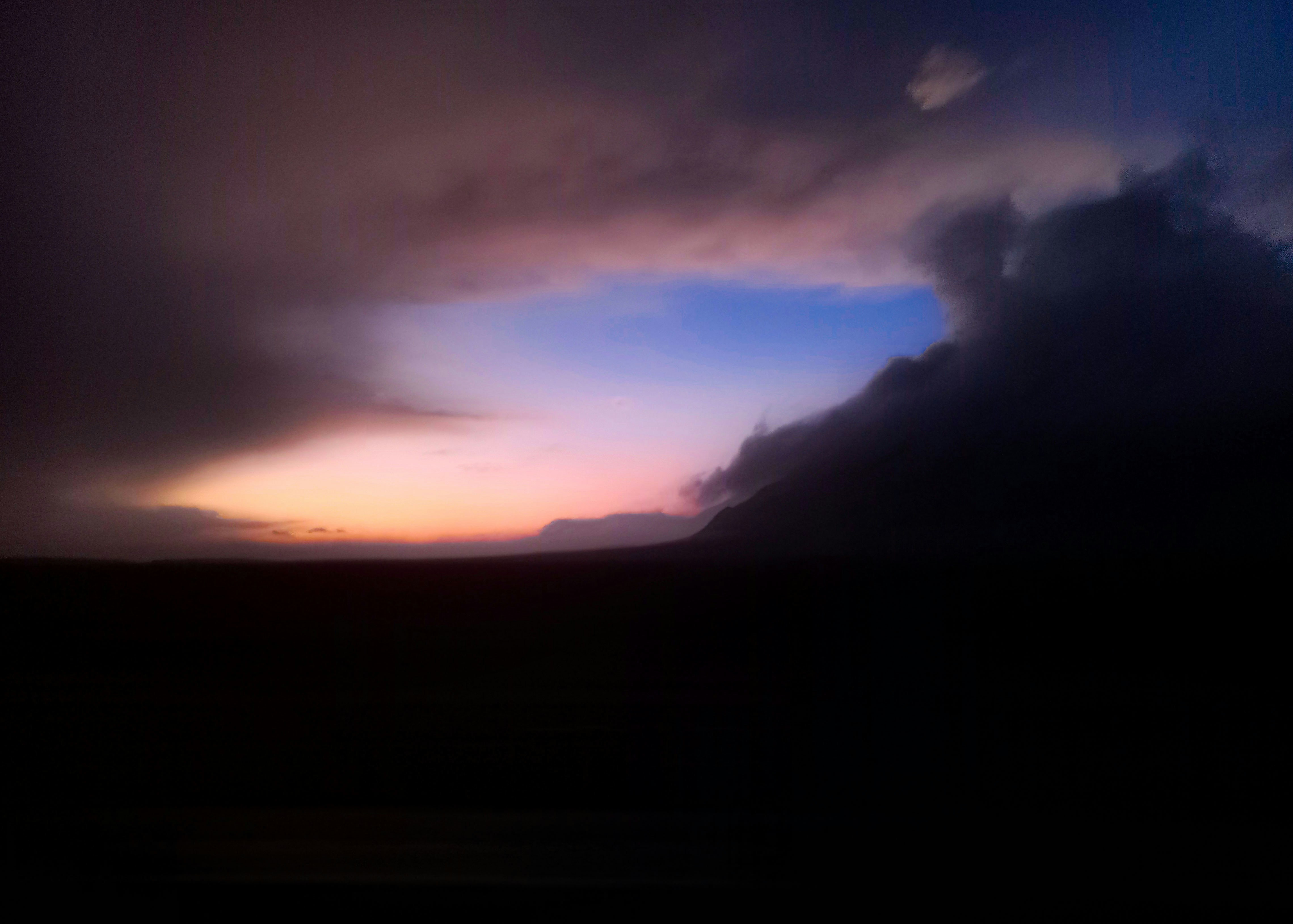 Dramatic sunset sky with dark clouds and colorful hues.