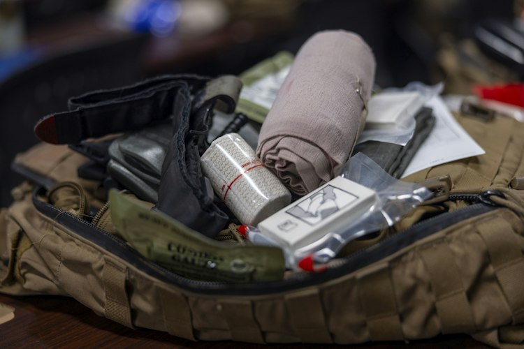 An organized first aid kit with bandages, gauze, and antiseptic laid out on a table