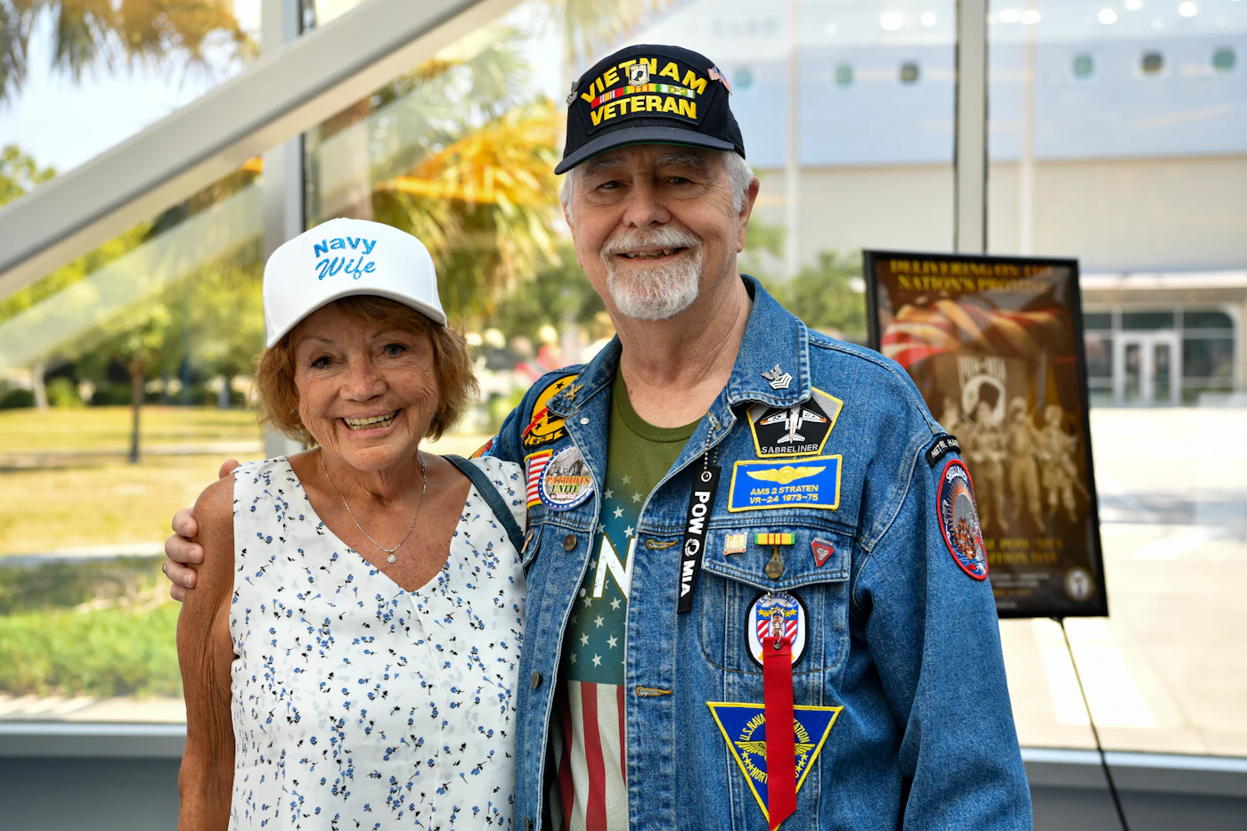 A veteran couple wearing service caps and patches