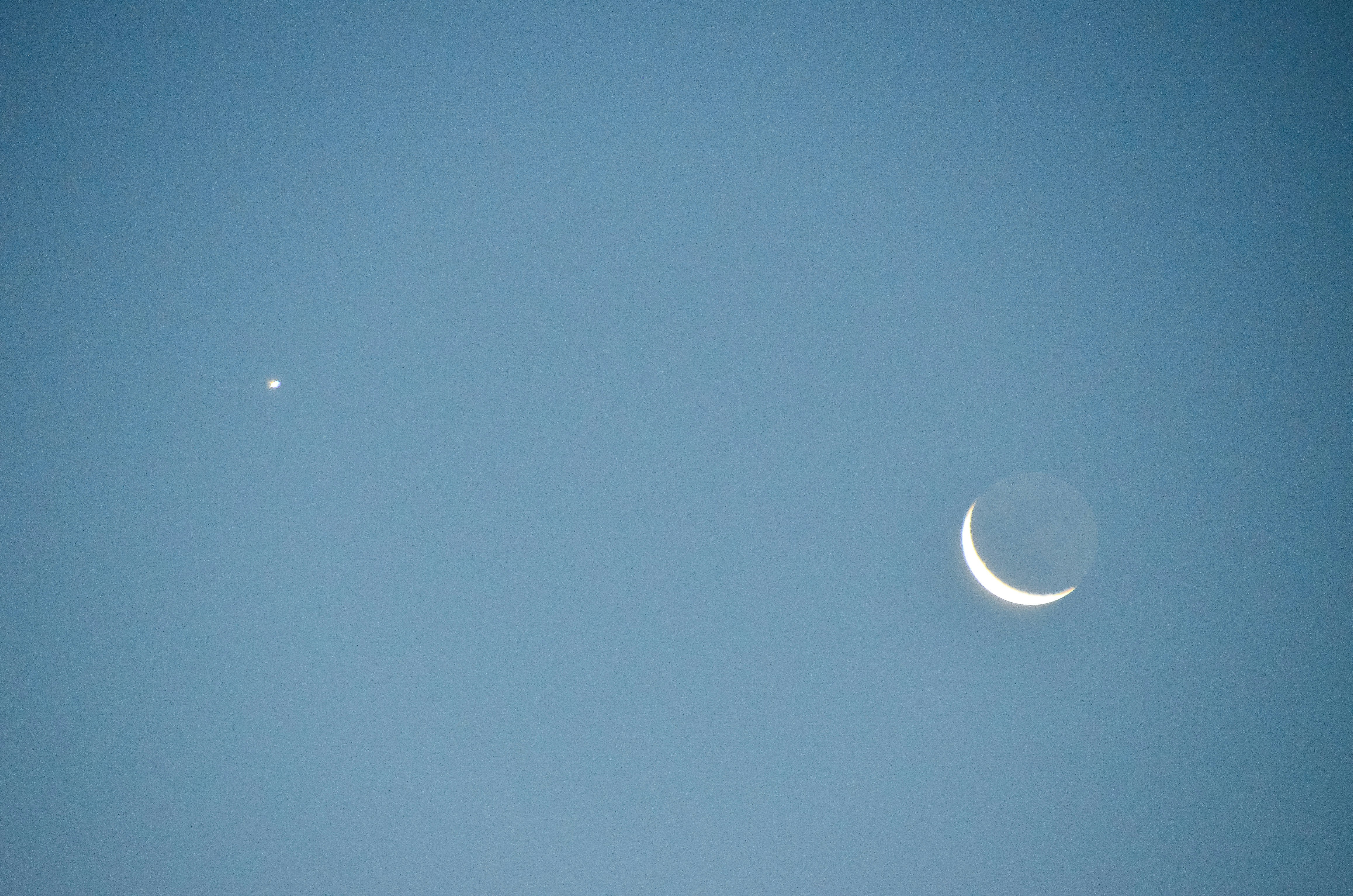 Crescent moon and bright star in clear sky