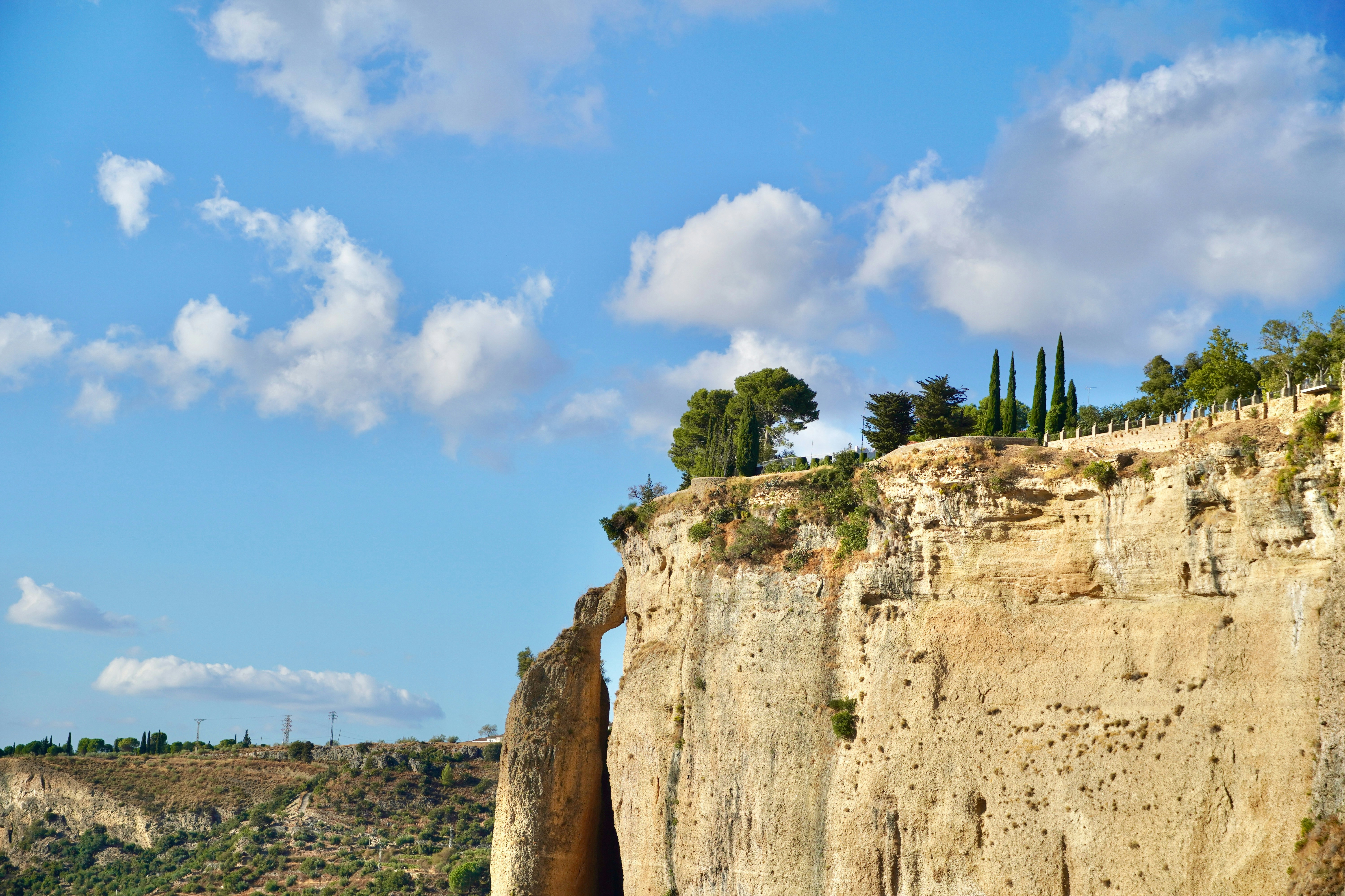 Cliffs with trees under a blue sky with clouds