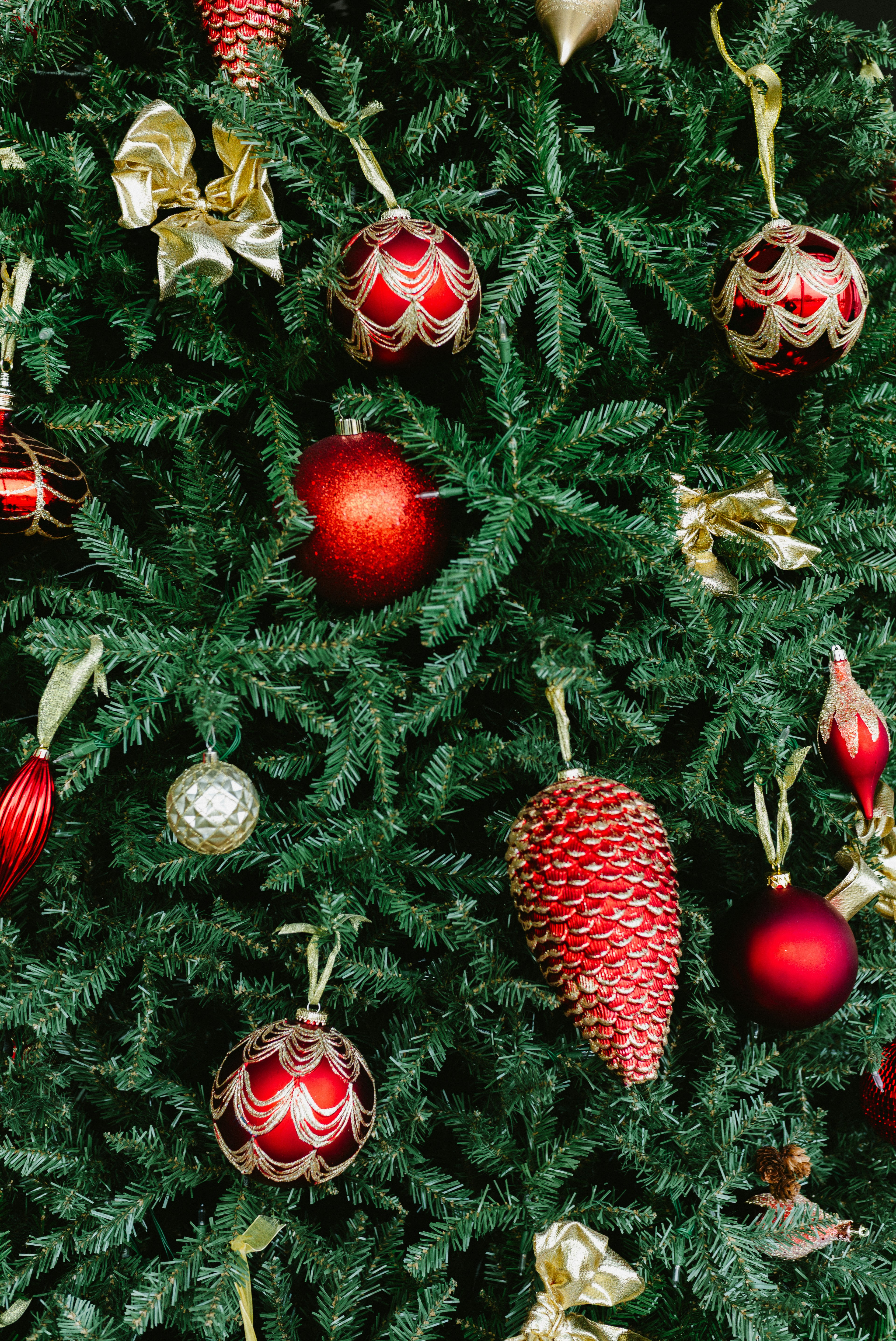 A decorated christmas tree with red and gold ornaments.