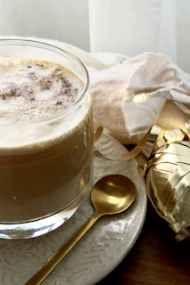 A warm cup of coffee with a golden spoon.