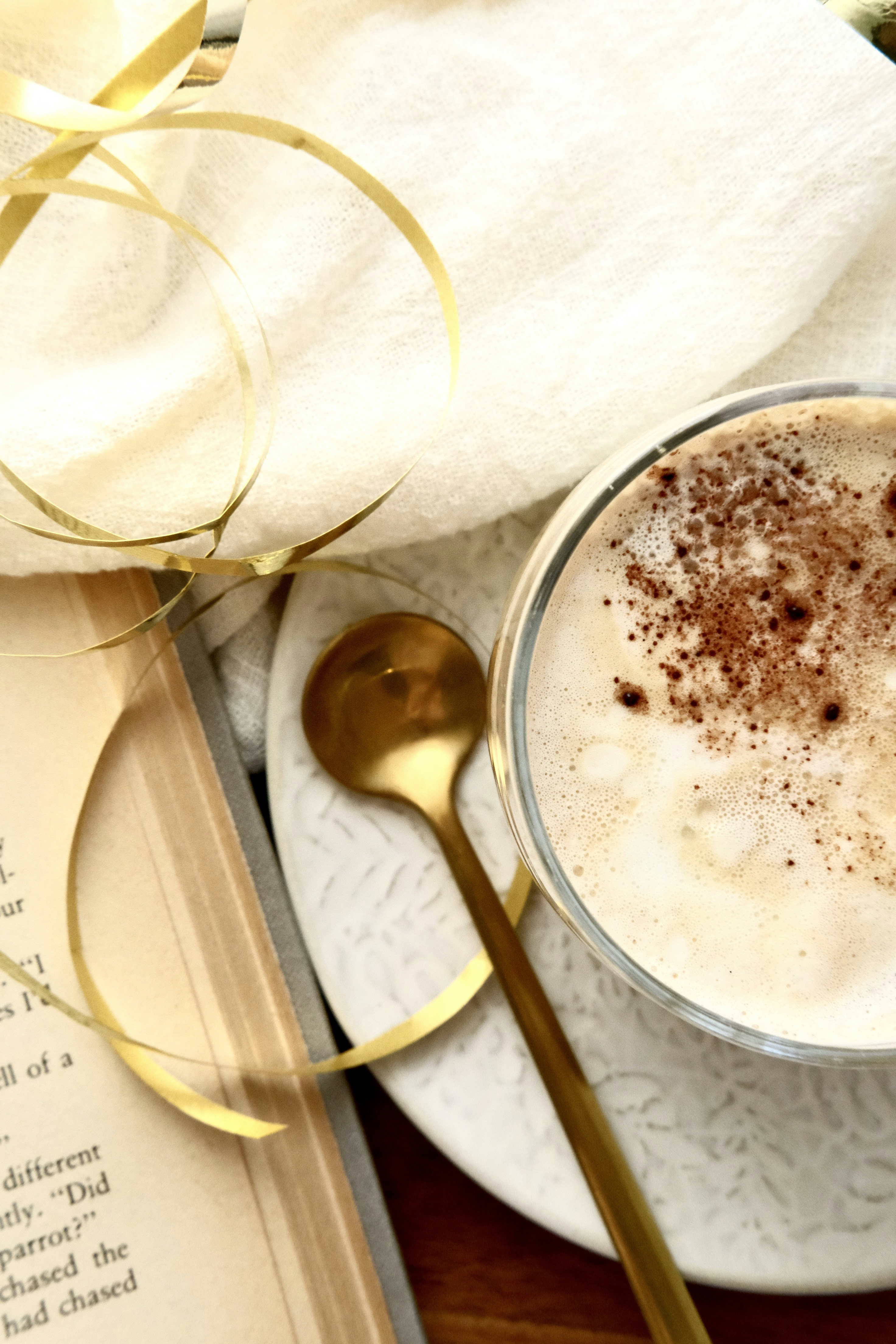 A cup of coffee with a spoon and a book