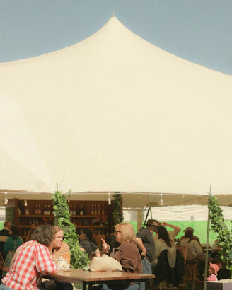 People gathered under a large white tent