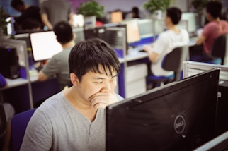 Man yawning while working at computer in office