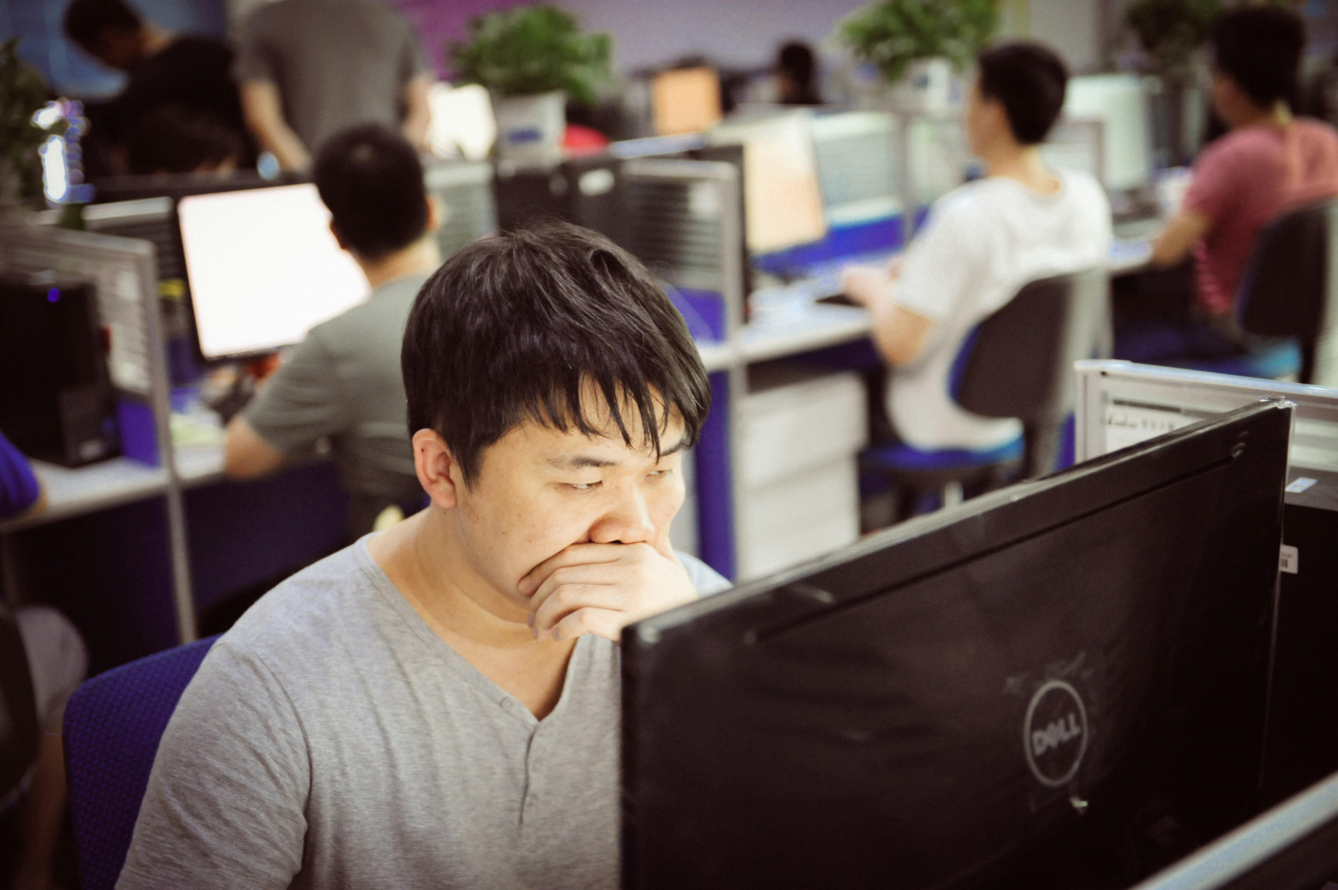 Man yawning while working at computer in office