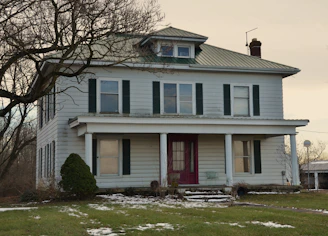 A two-story farmhouse with a covered porch.