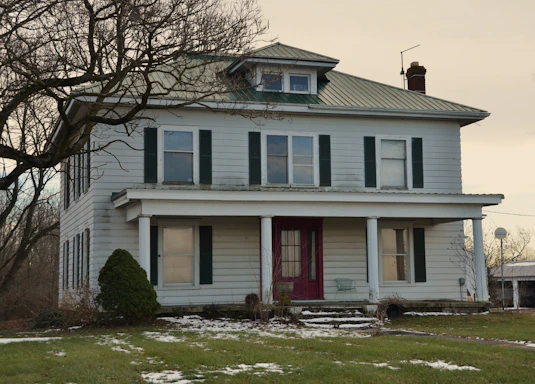 A two-story farmhouse with a covered porch.