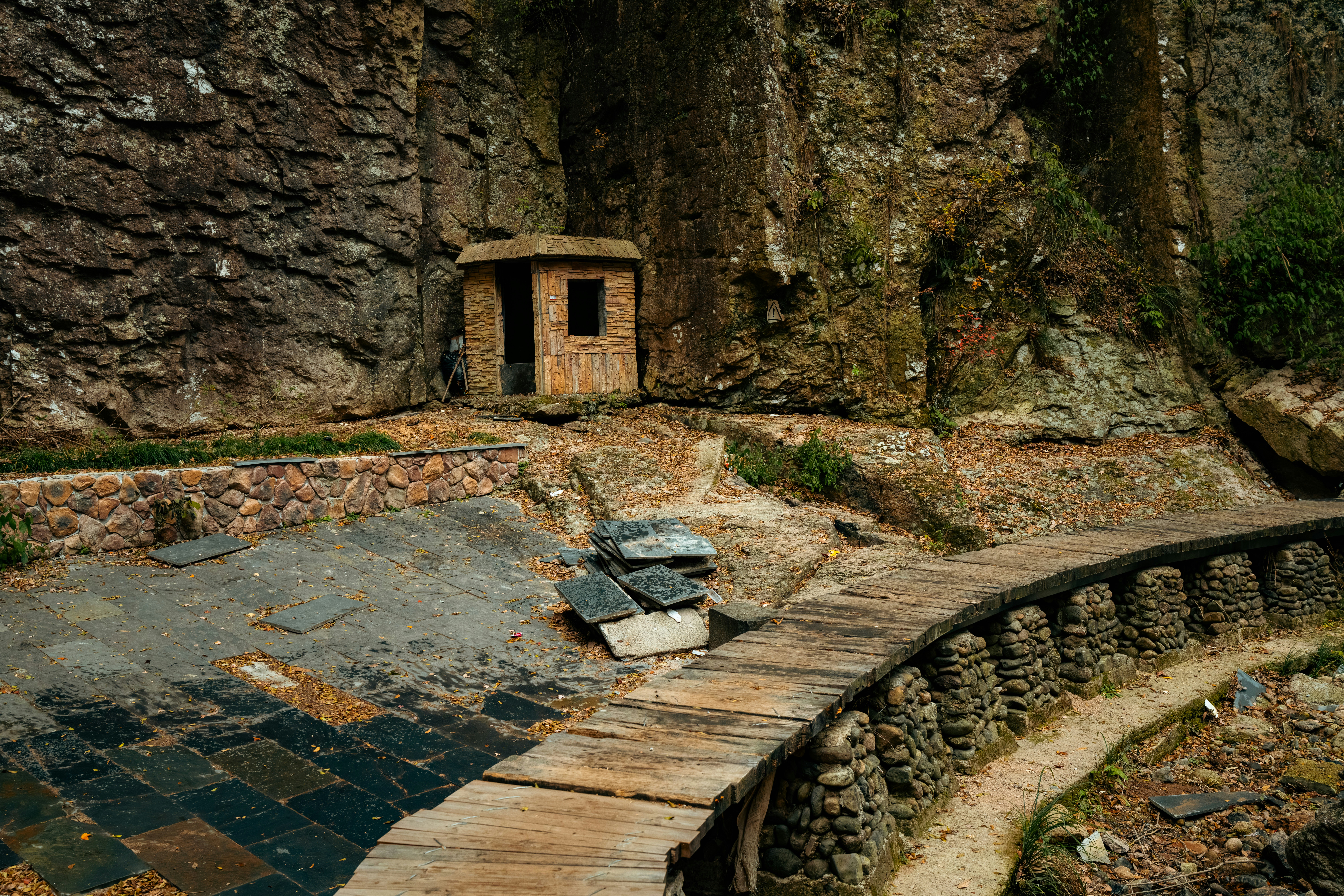 Small hut nestled against rocky cliff face
