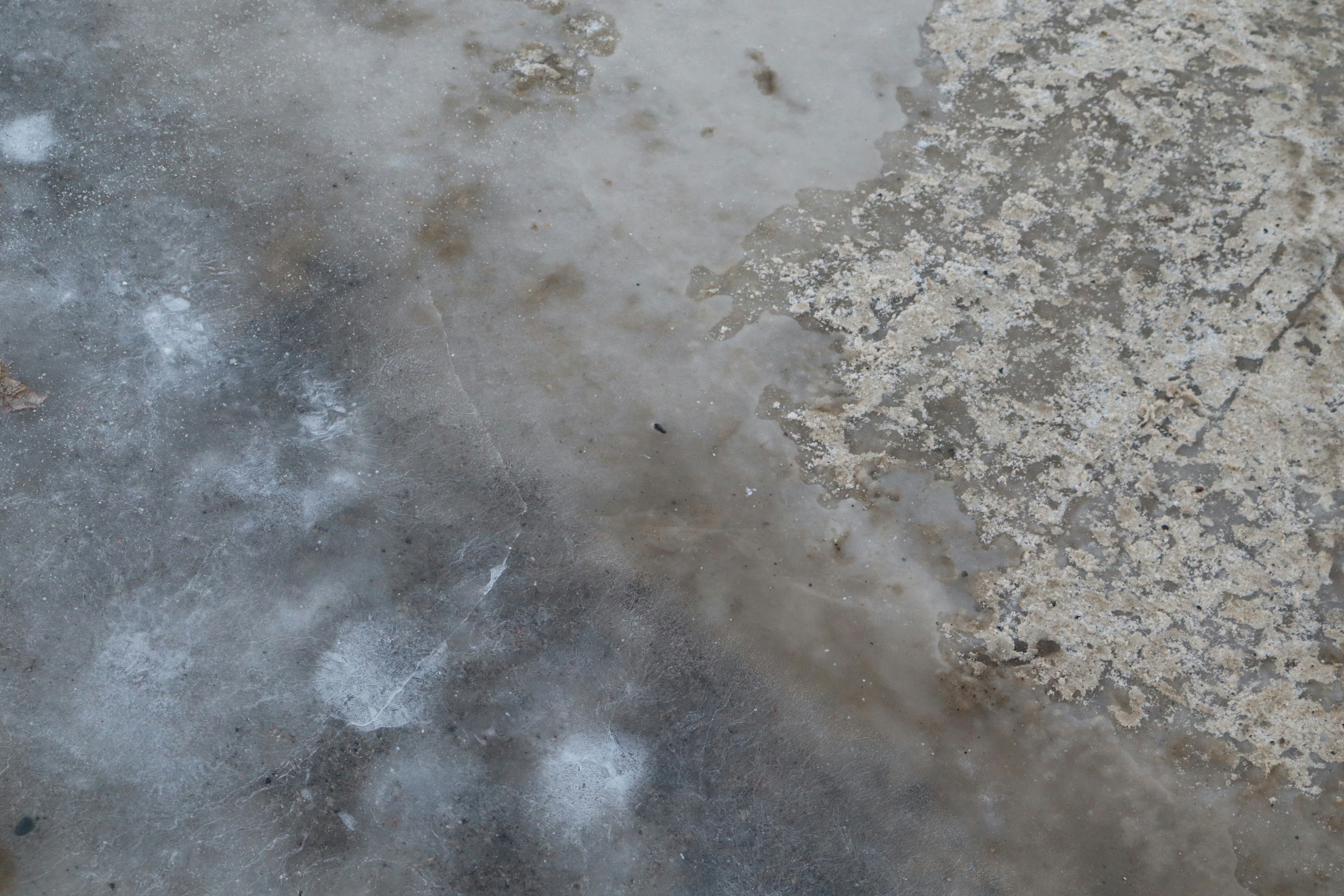 Close-up of icy ground with concrete texture