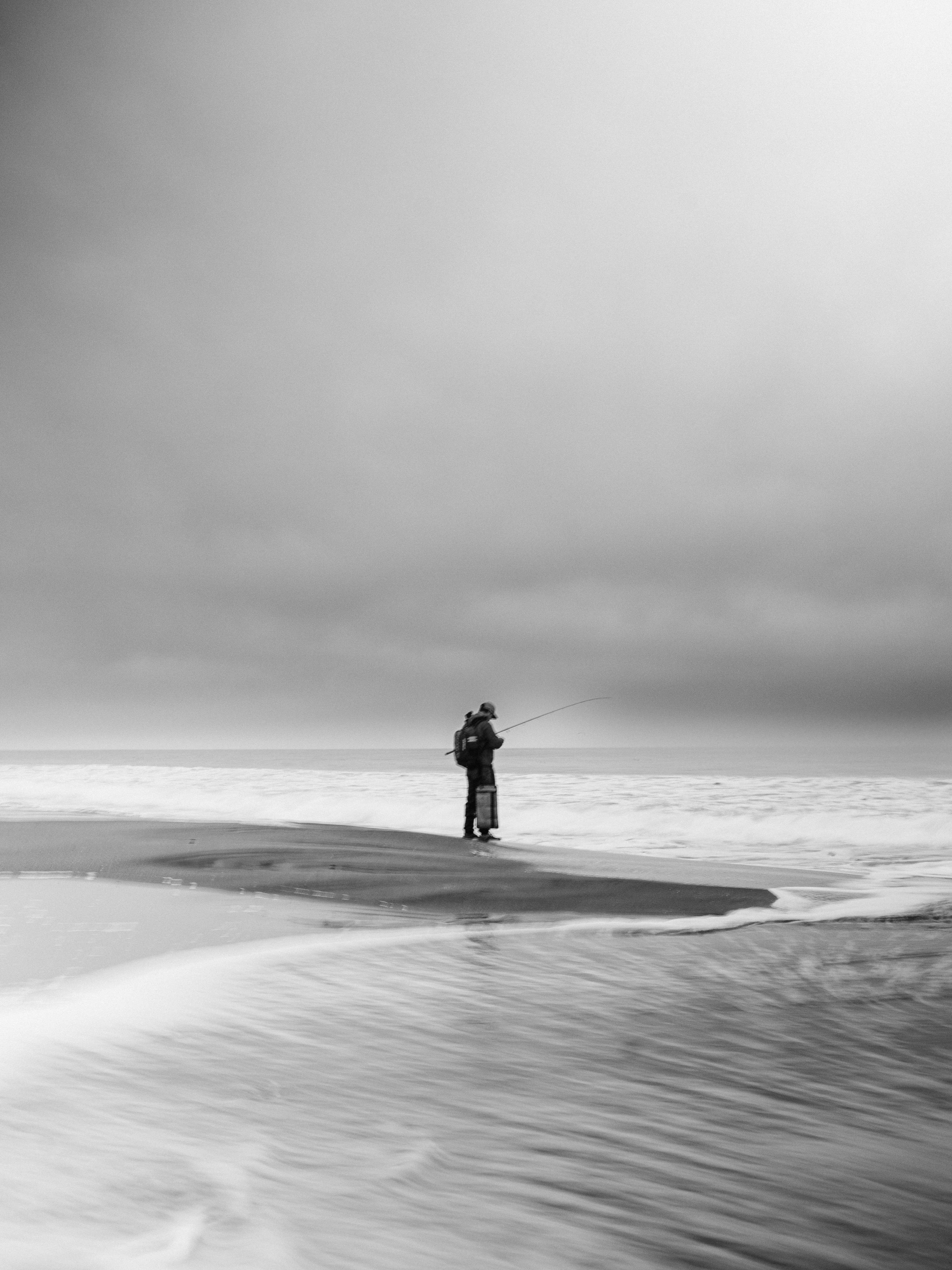 Fisherman casting line on a stormy beach