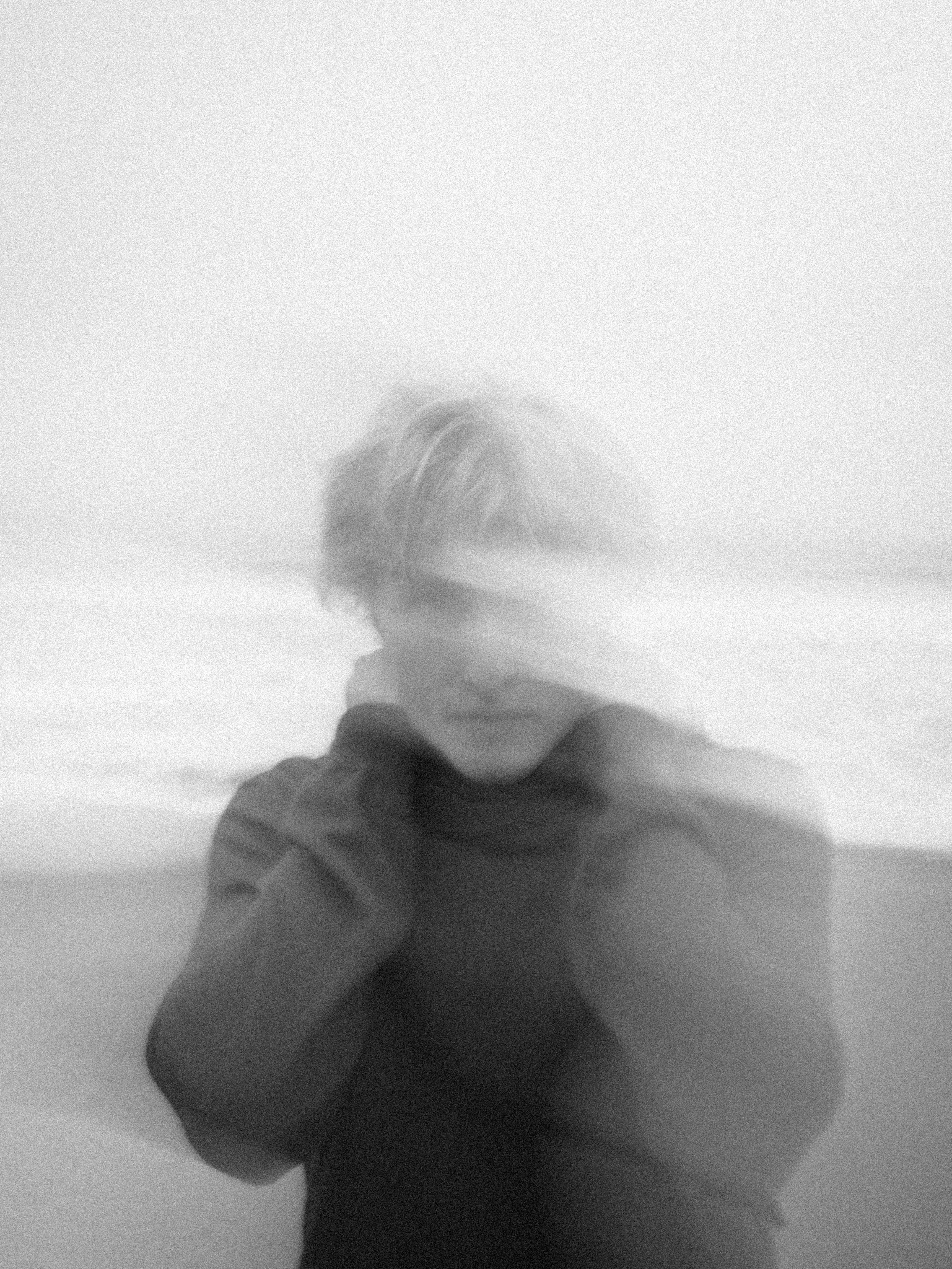 A person stands on a beach with blurred features.