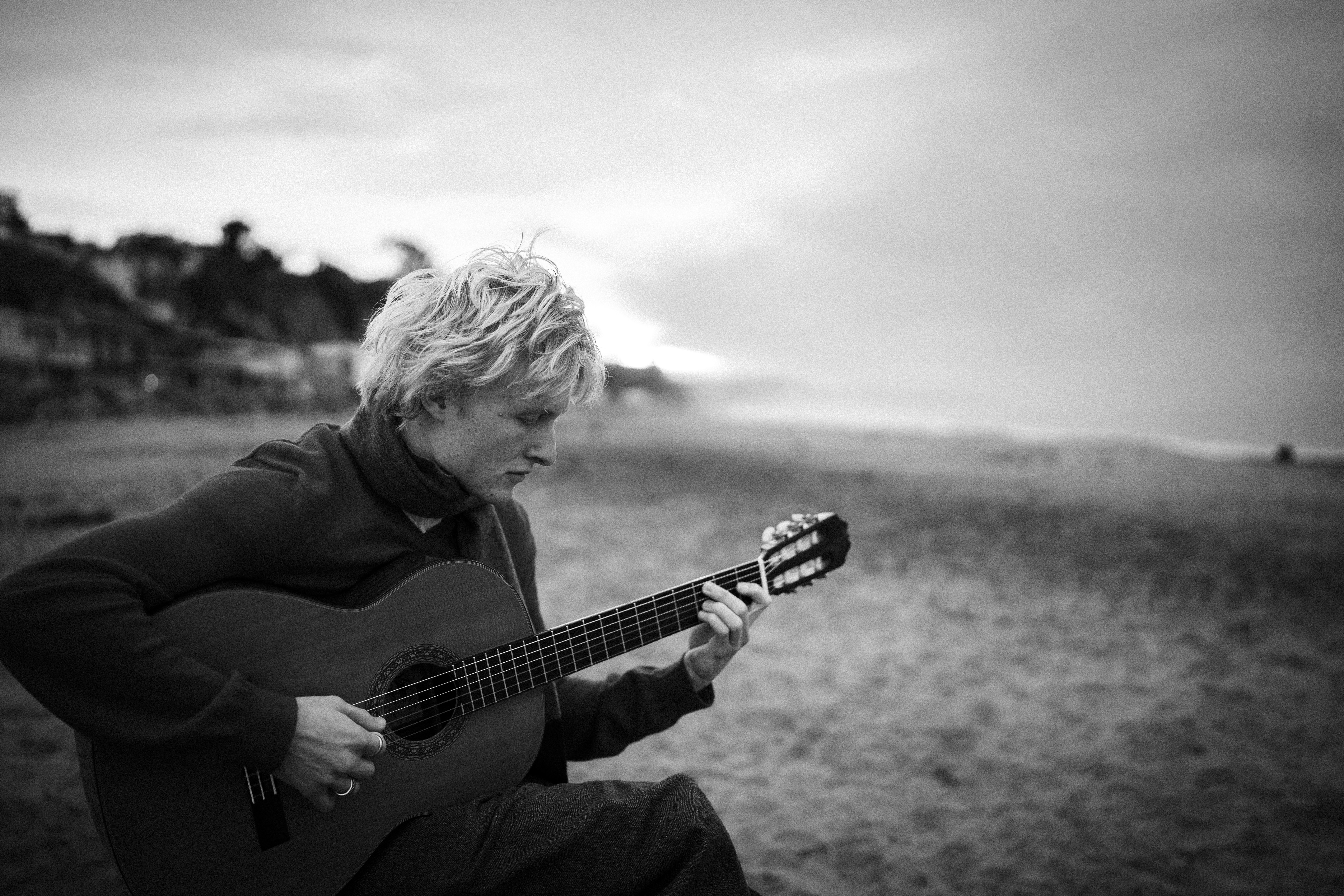 Woman playing guitar on a sandy beach