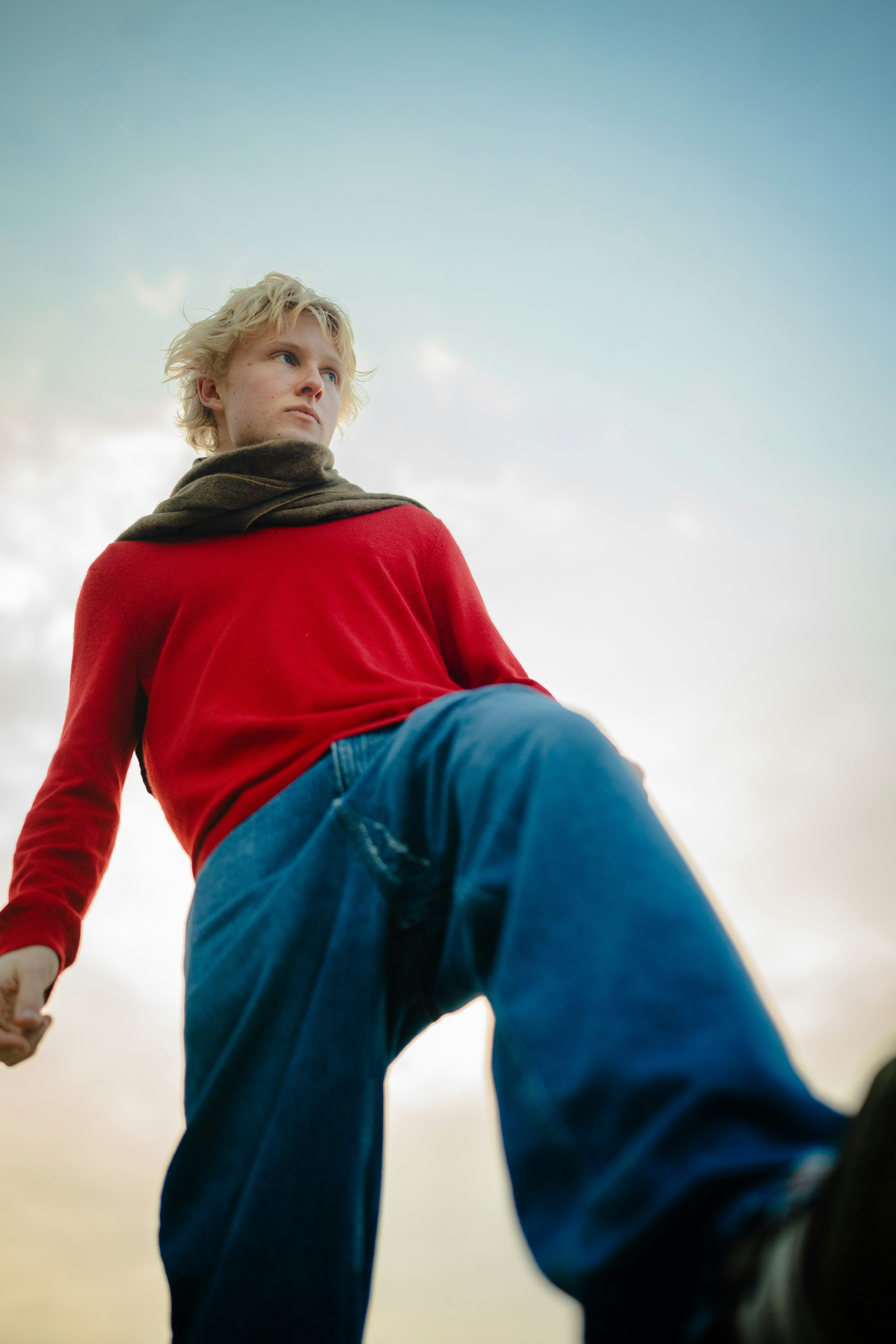 A young man in a red sweater and jeans
