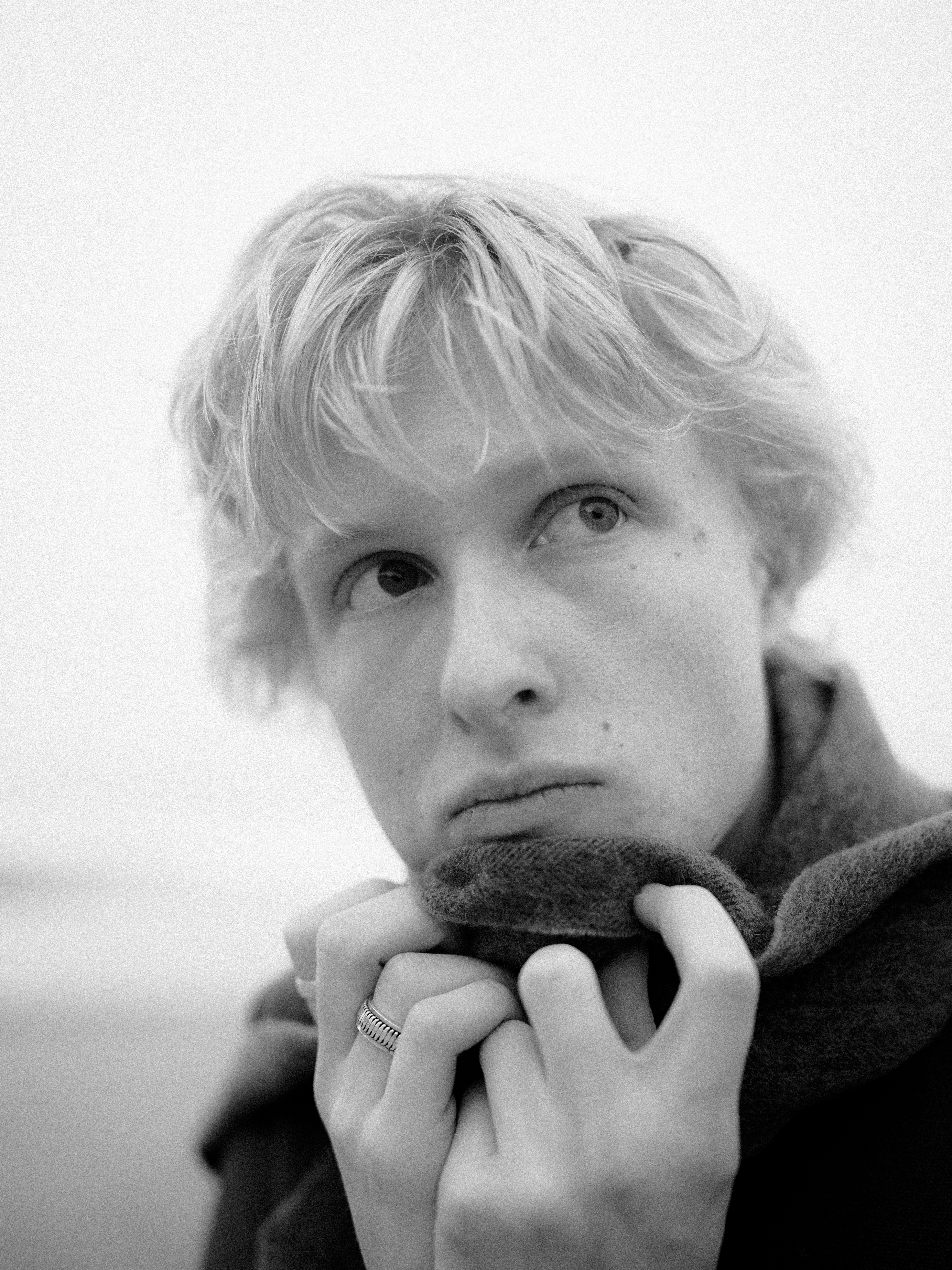 Young man with blonde hair wearing a scarf