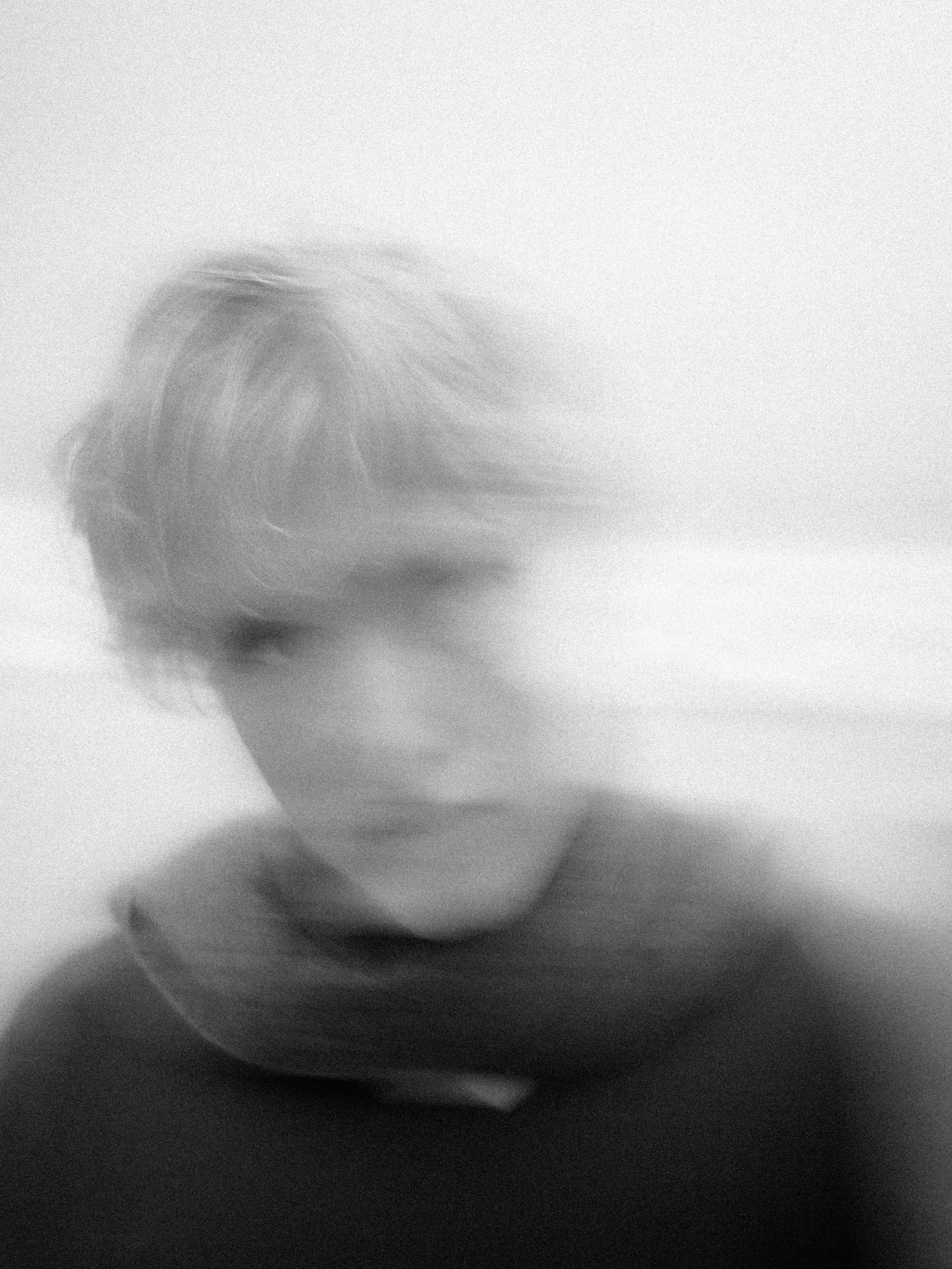 Blurred portrait of a person wearing a scarf.