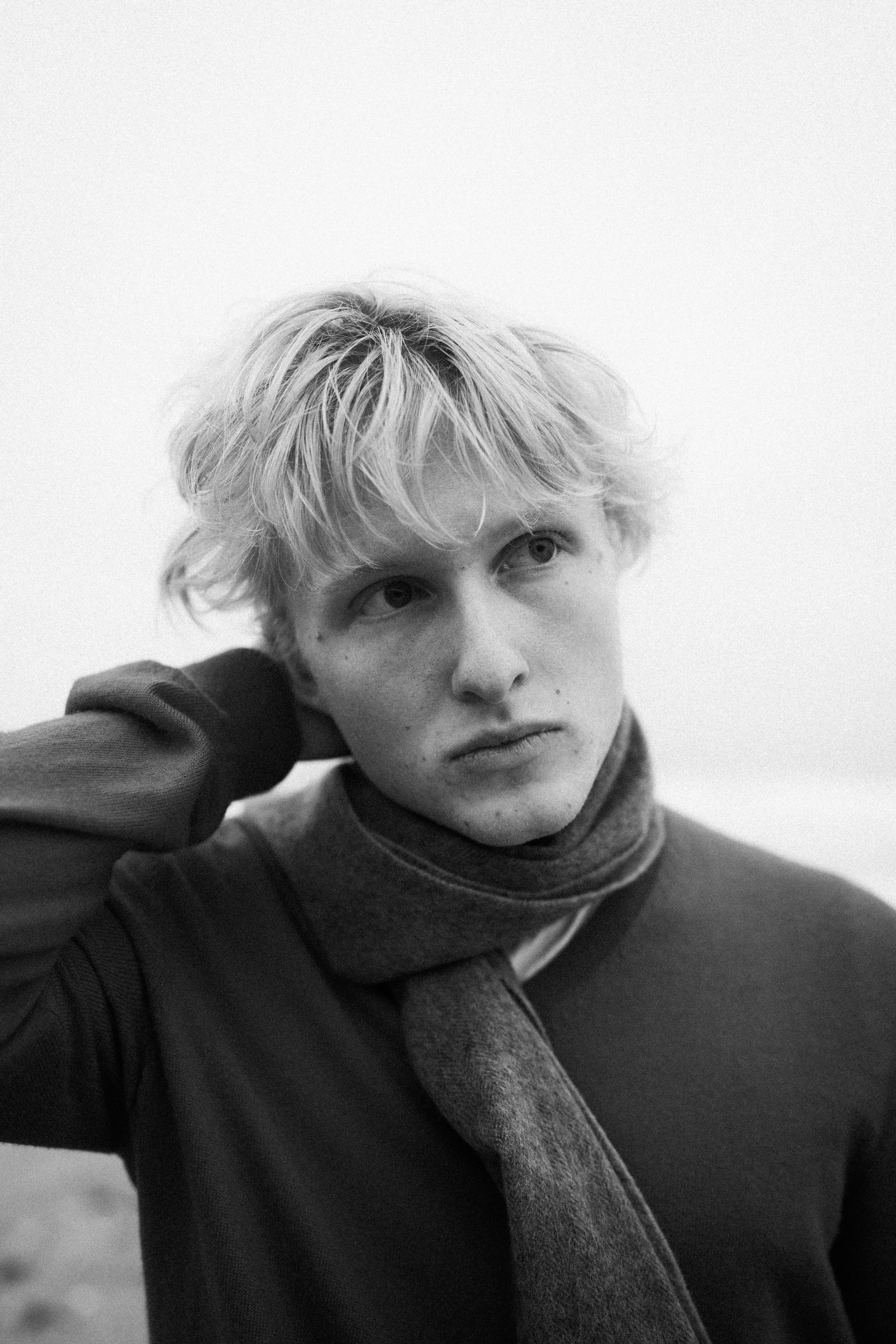 Young man with blond hair wearing a scarf