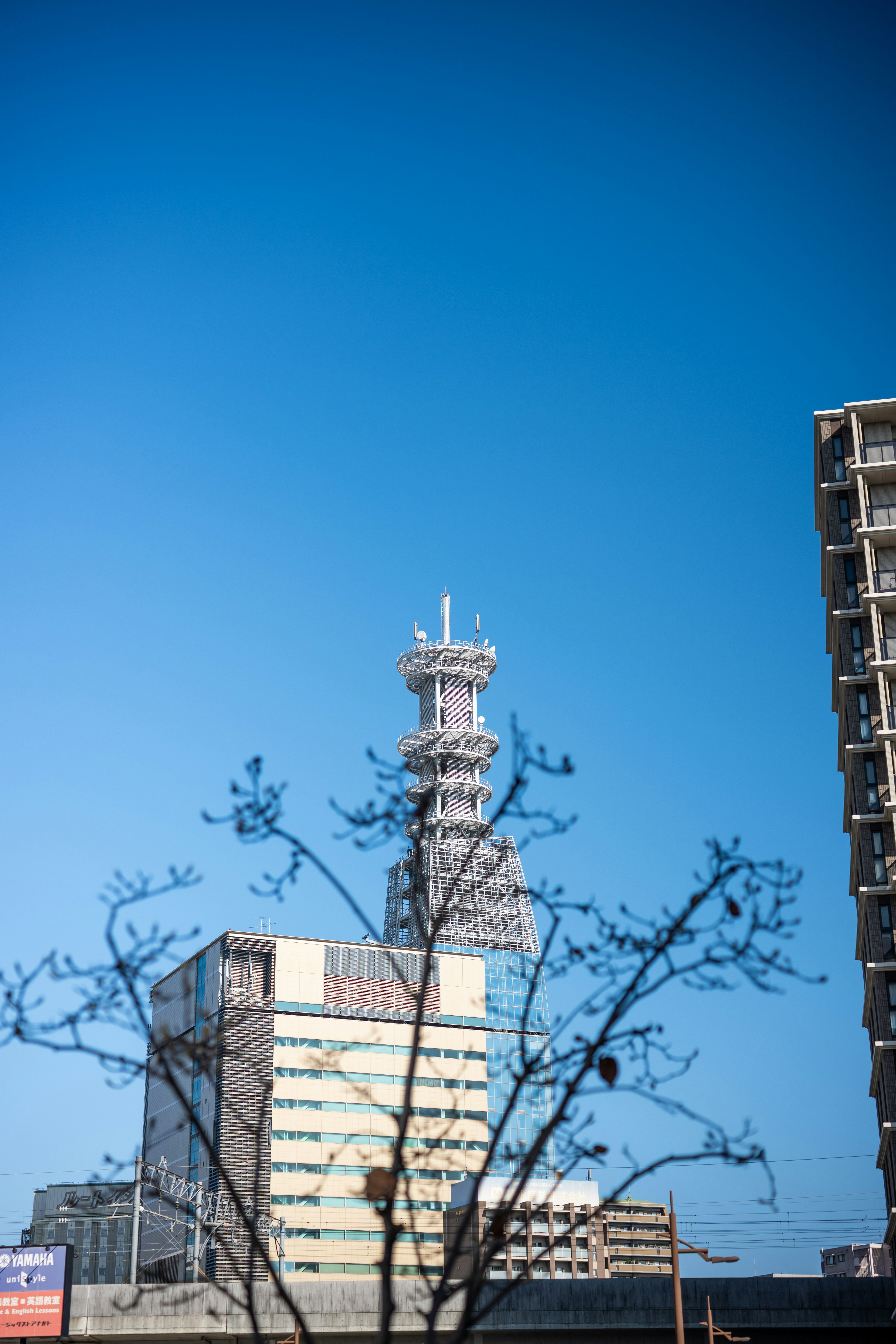 A telecommunications tower stands tall against a clear blue sky.