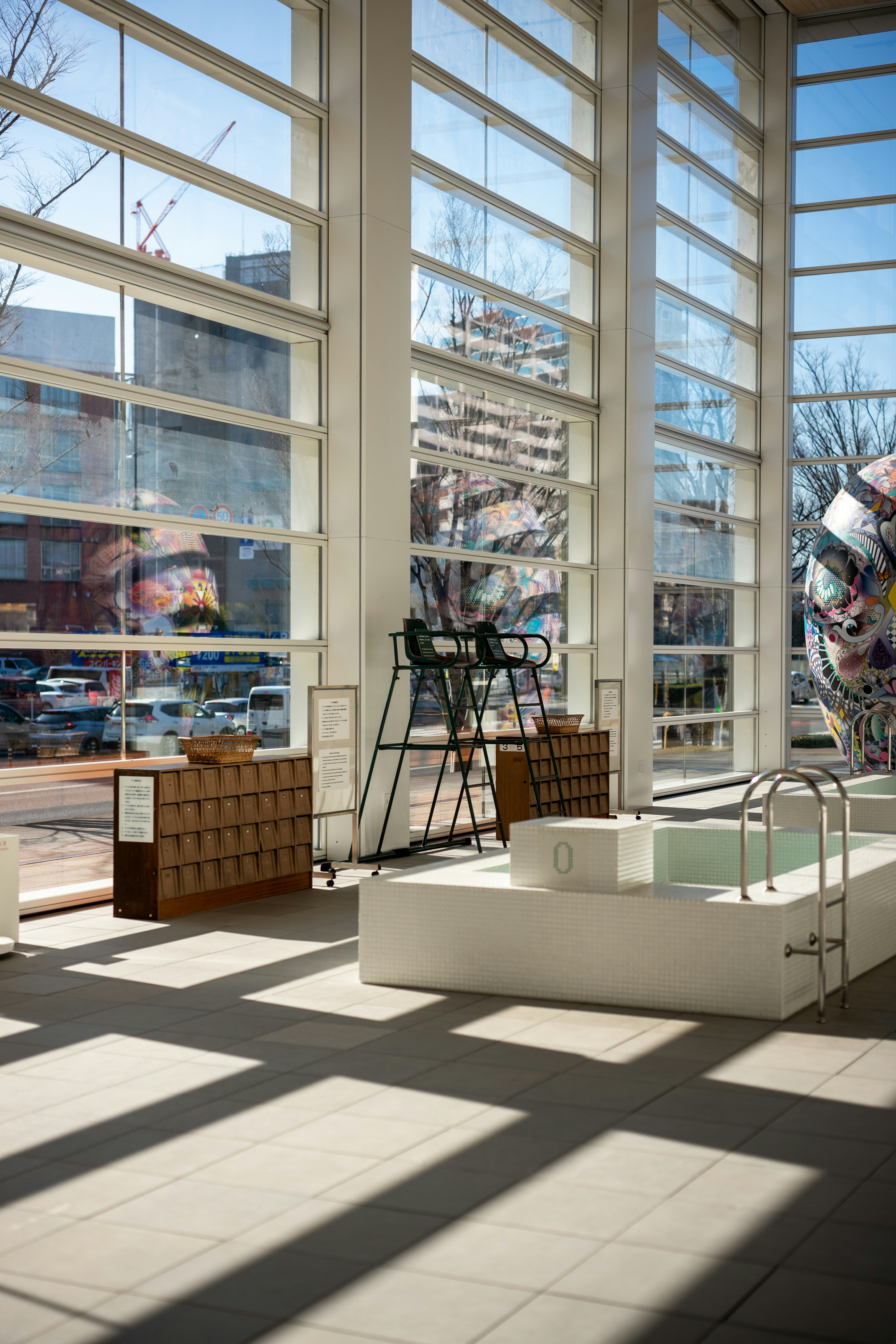 Modernes Gebäudeinterieur mit großen Fenstern und Pool.