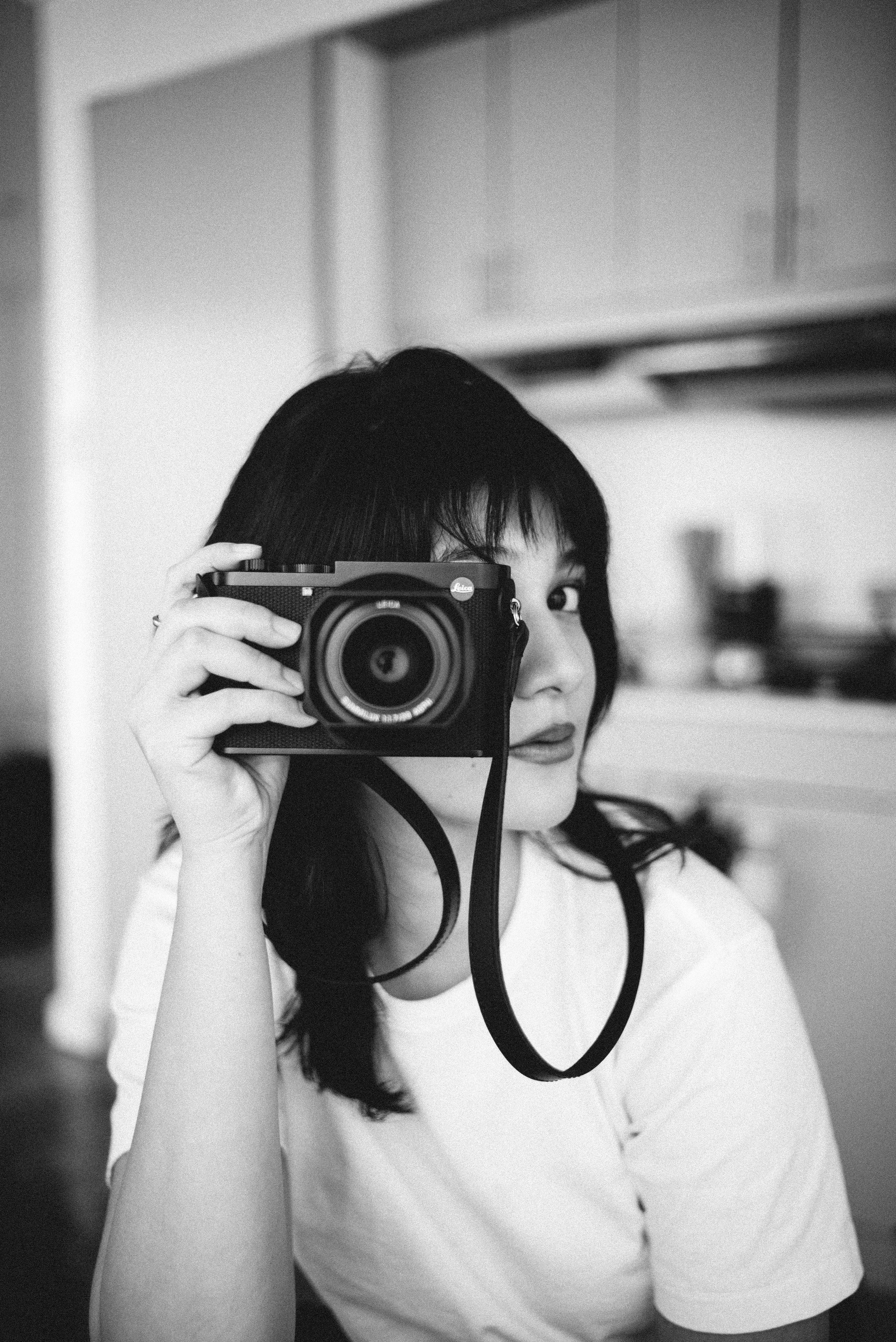 Woman holding a camera in front of her face