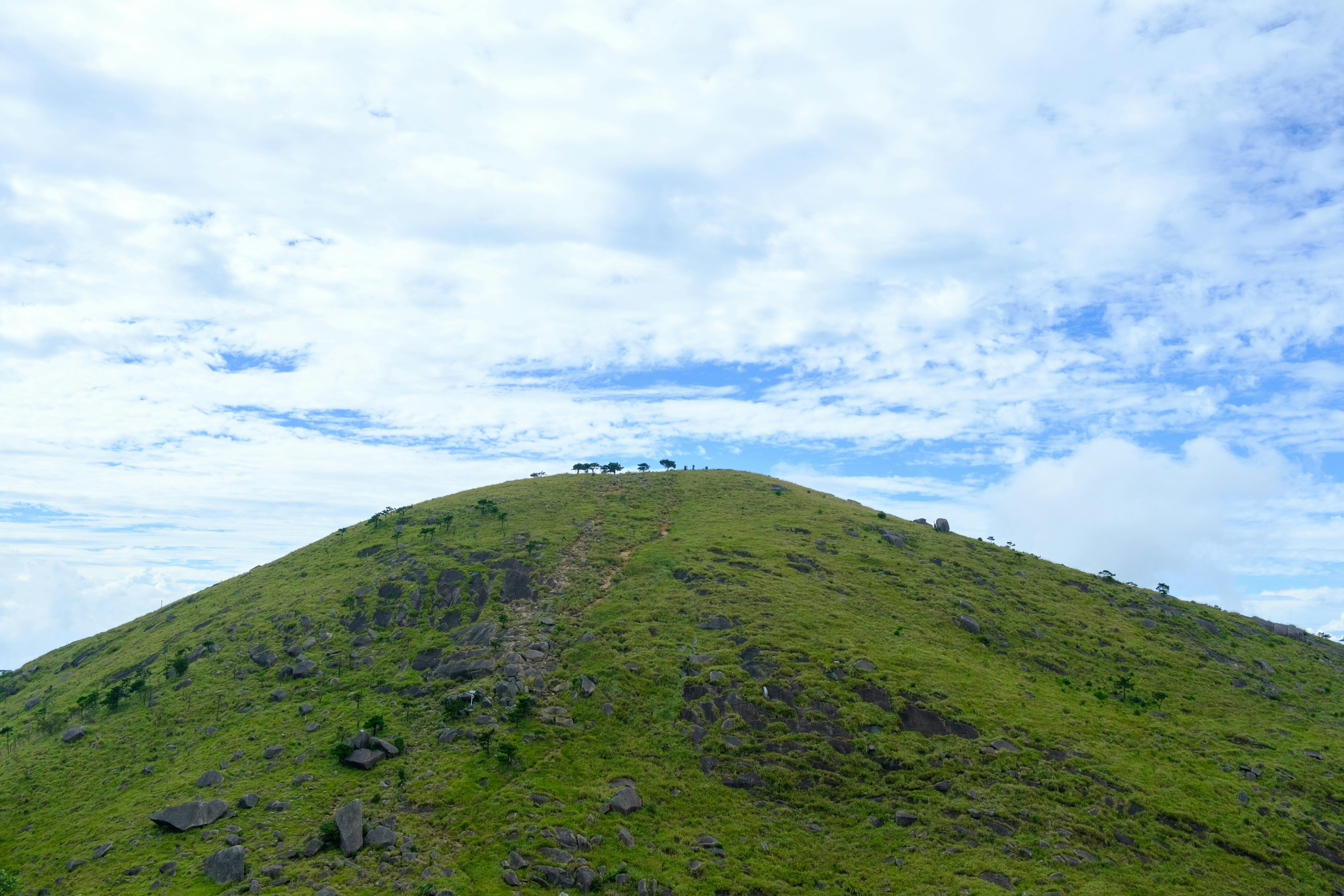 Green grassy hill under a cloudy sky.